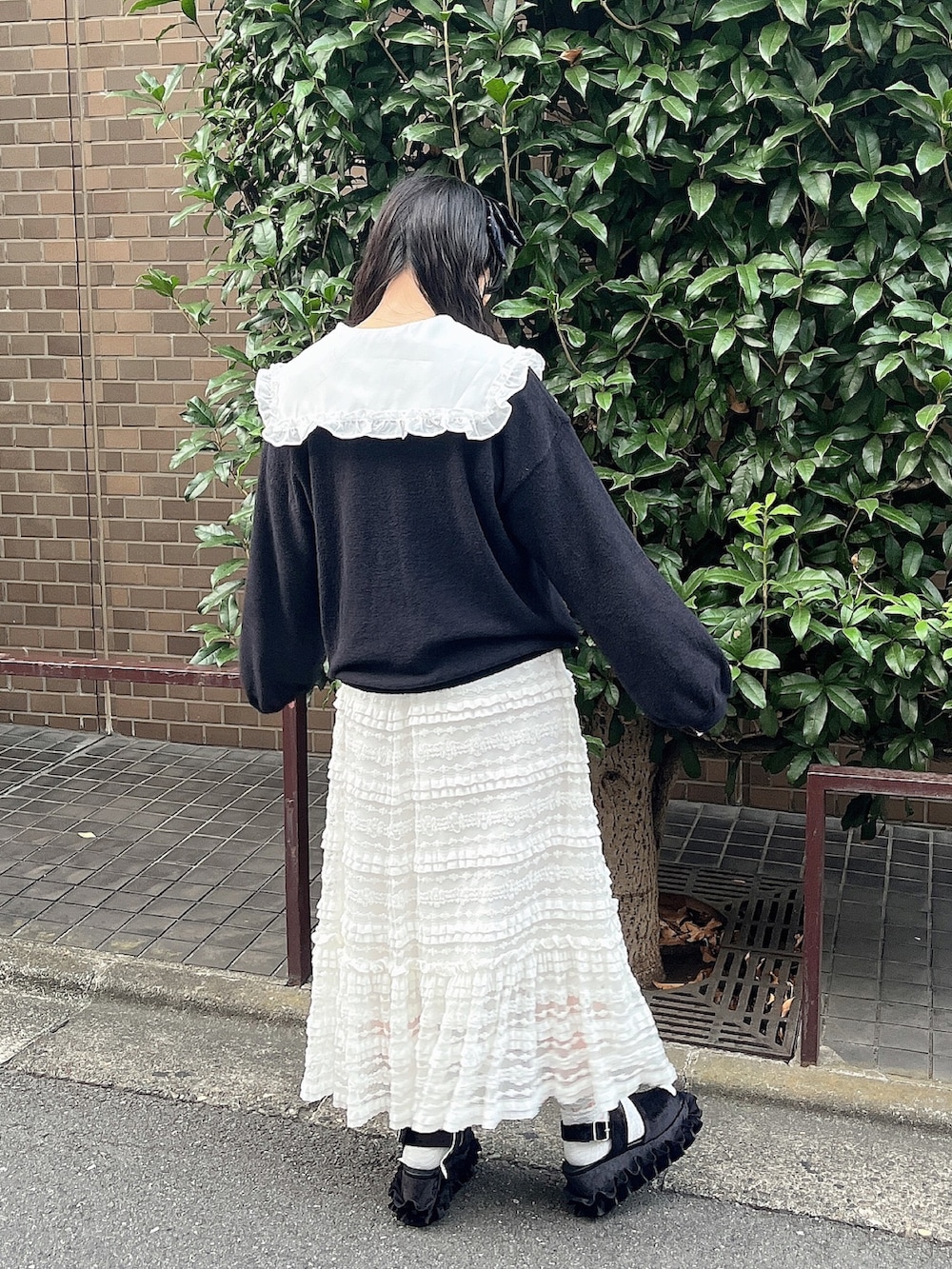 ホワイト系のシャツ/ブラウス、ブラック系のカーディガン/ボレロ、ホワイト系のスカートを着用したレディースの夏コーディネートの3枚目の写真