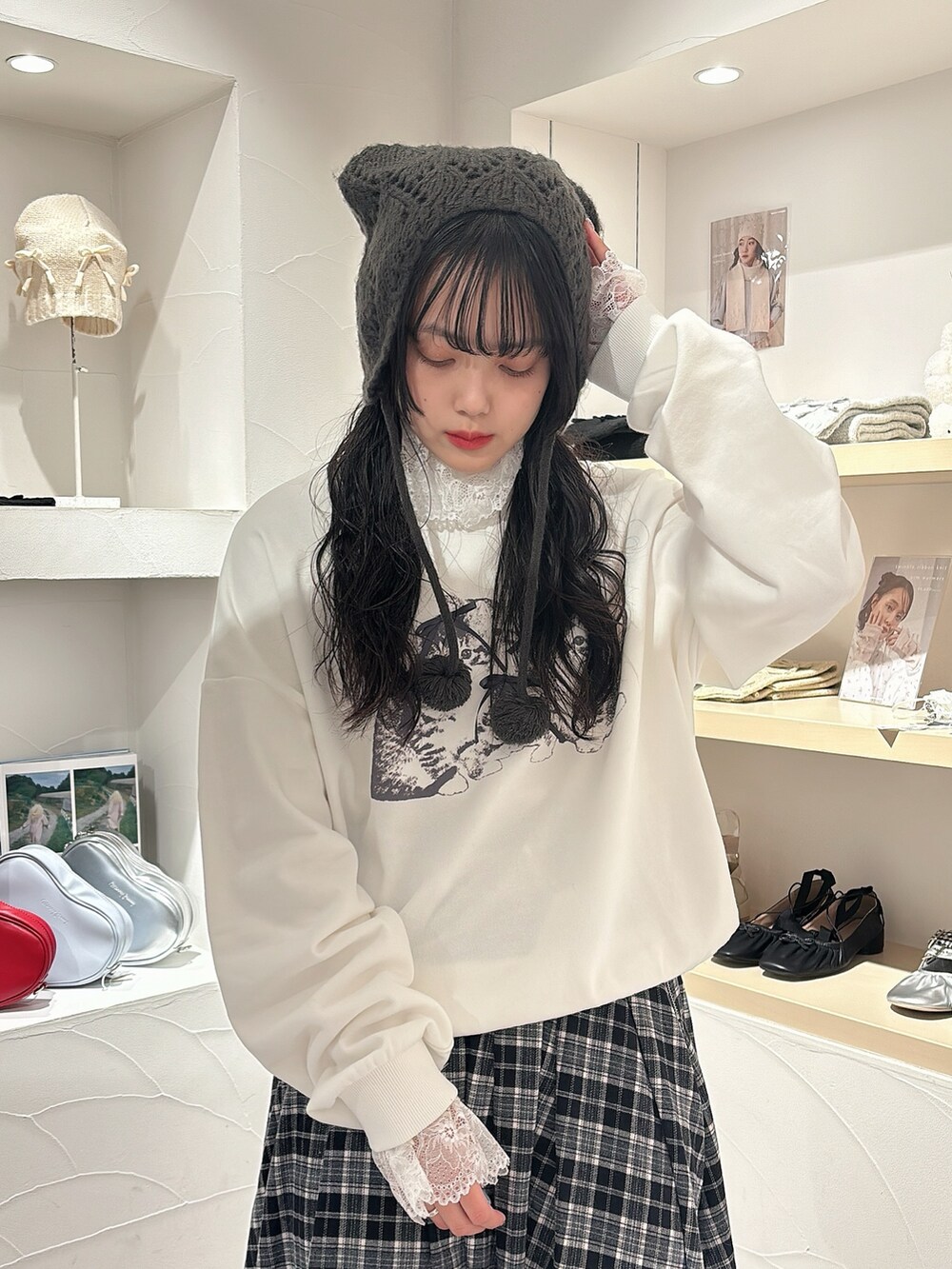 ホワイト系のニット/セーター、ホワイト系のスウェット、ブラック系のスカートを着用したレディースの秋コーディネートの5枚目の写真