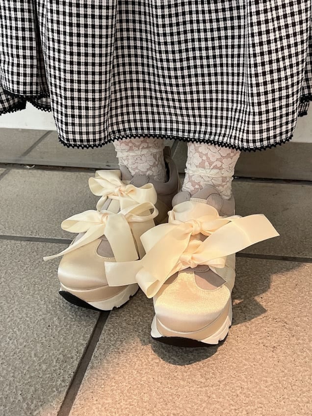 ホワイト系のシャツ/ブラウス、ホワイト系のスニーカー、ブラック系のスカートを着用したレディースの夏コーディネートの5枚目の写真