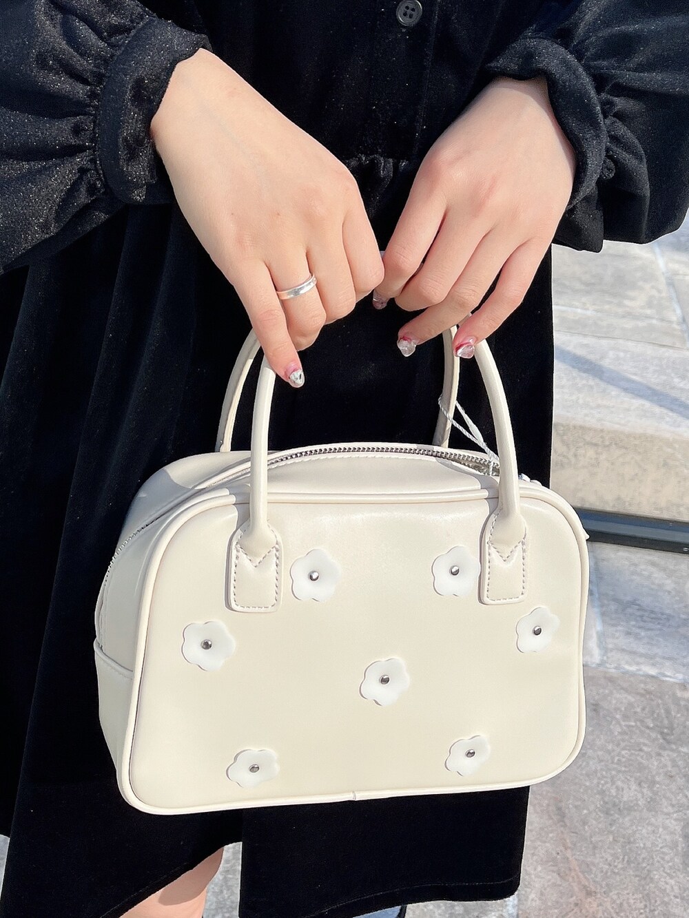 ブラック系のワンピース、ホワイト系のボストンバッグ、ブラック系のブーツを着用したレディースの冬コーディネートの7枚目の写真