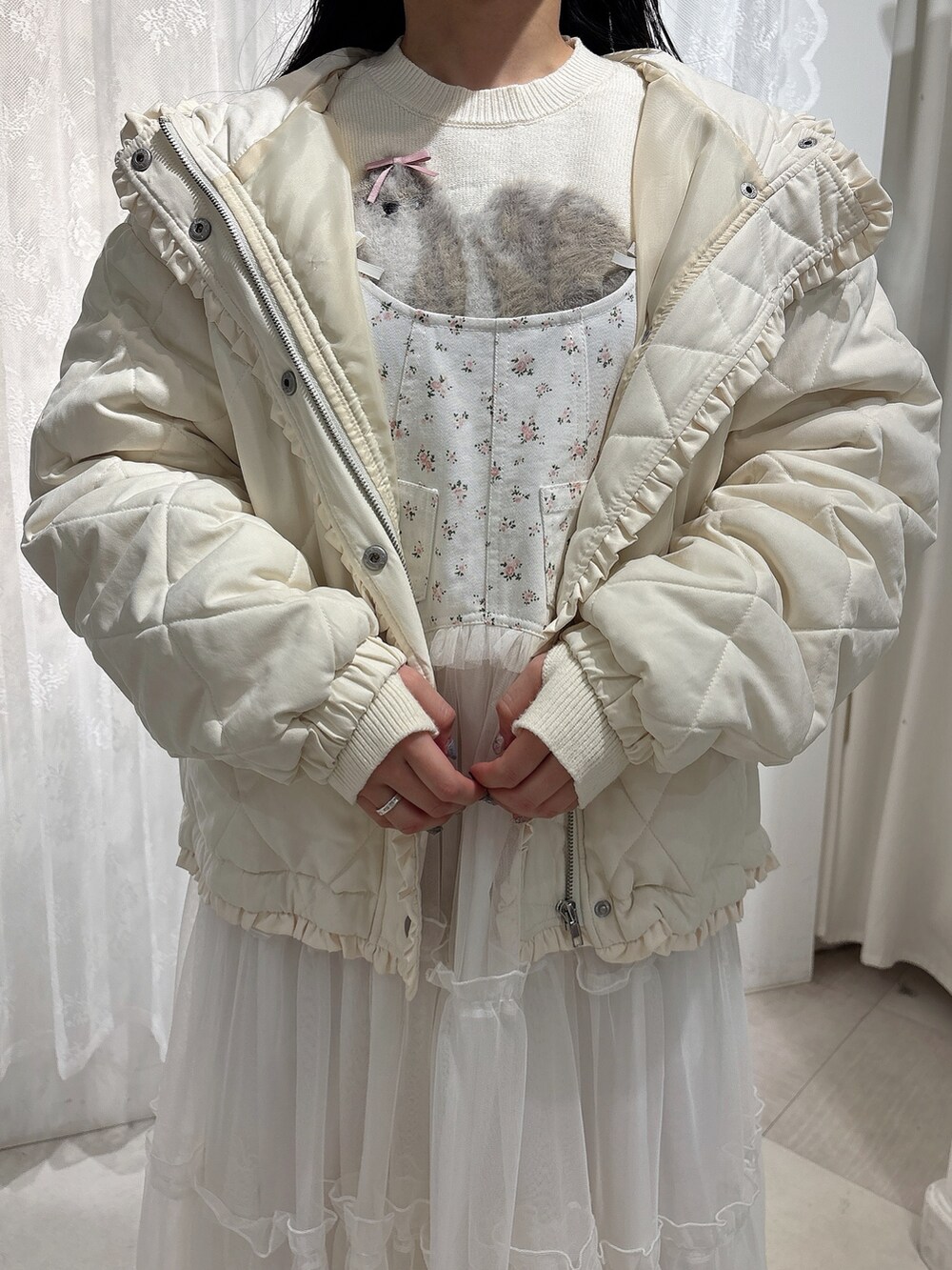 ホワイト系のニット/セーター、ホワイト系のダウンジャケット/コート、ホワイト系のワンピースを着用したレディースの冬コーディネートの8枚目の写真