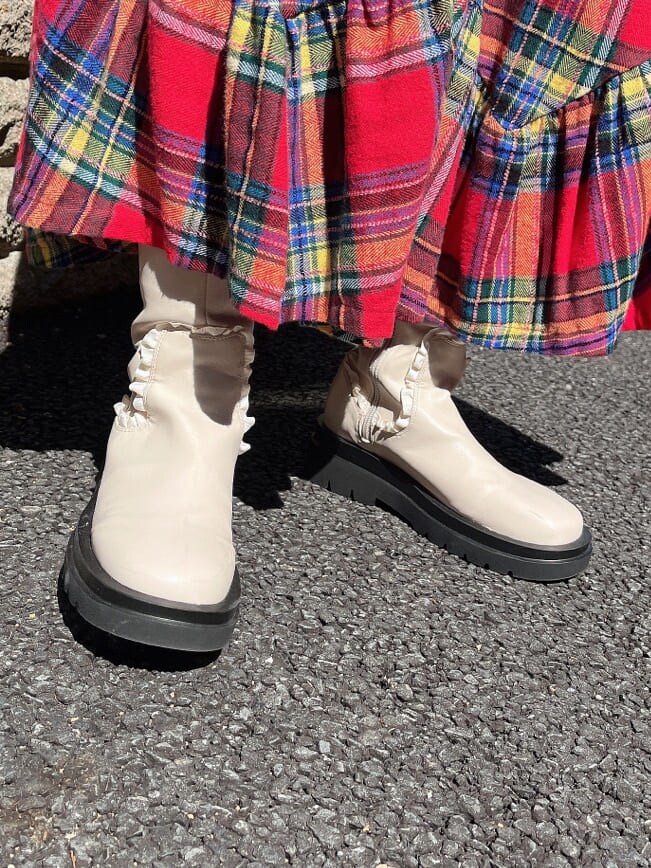 ホワイト系のシャツ/ブラウス、ホワイト系のブーツ、レッド系のスカートを着用したレディースの秋コーディネートの4枚目の写真