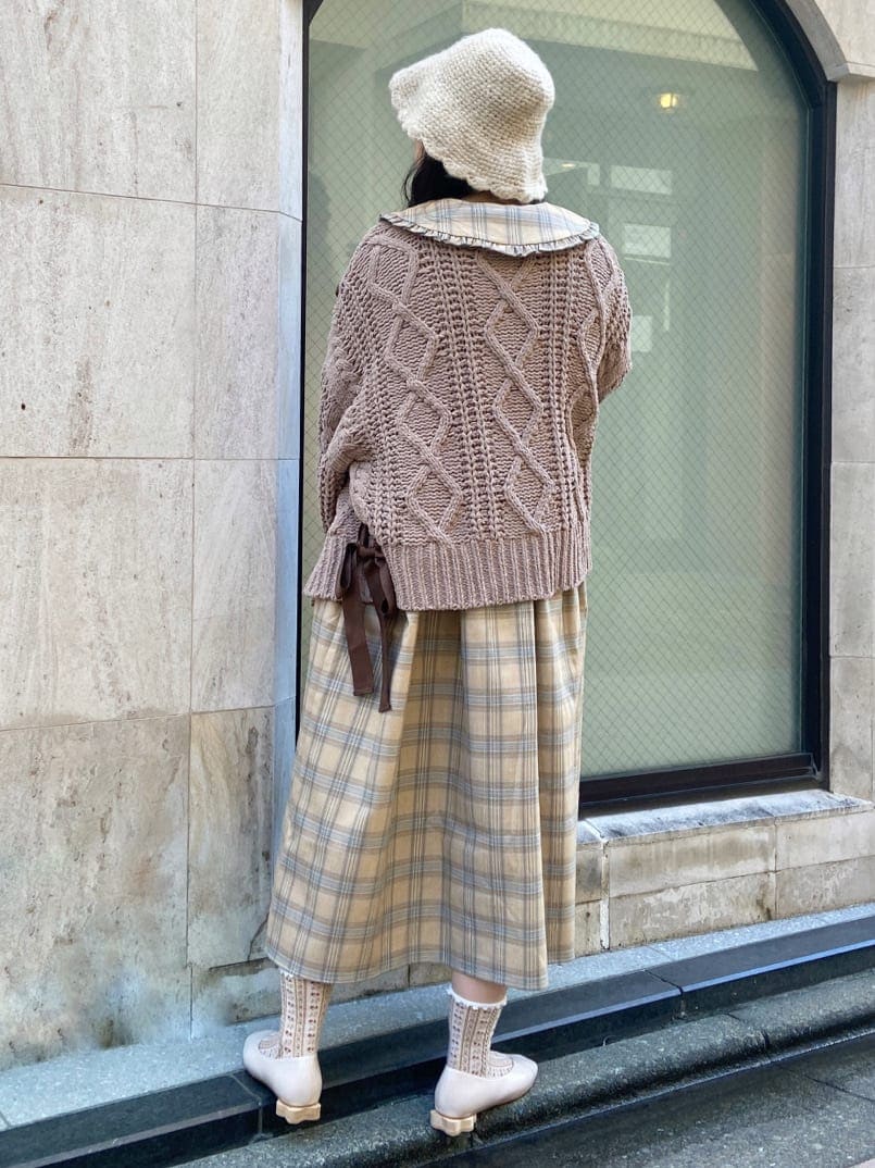 ベージュ系のワンピース、ホワイト系のパンプス、ブラウン系のカーディガン/ボレロを着用したレディースの秋コーディネートの3枚目の写真