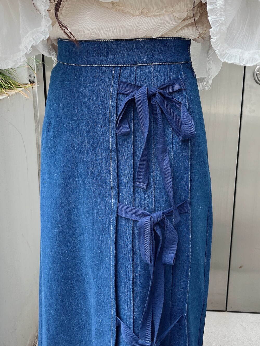 ベージュ系のTシャツ/カットソー、ホワイト系のシャツ/ブラウス、ブルー系のデニムスカートを着用したレディースの夏コーディネートの6枚目の写真