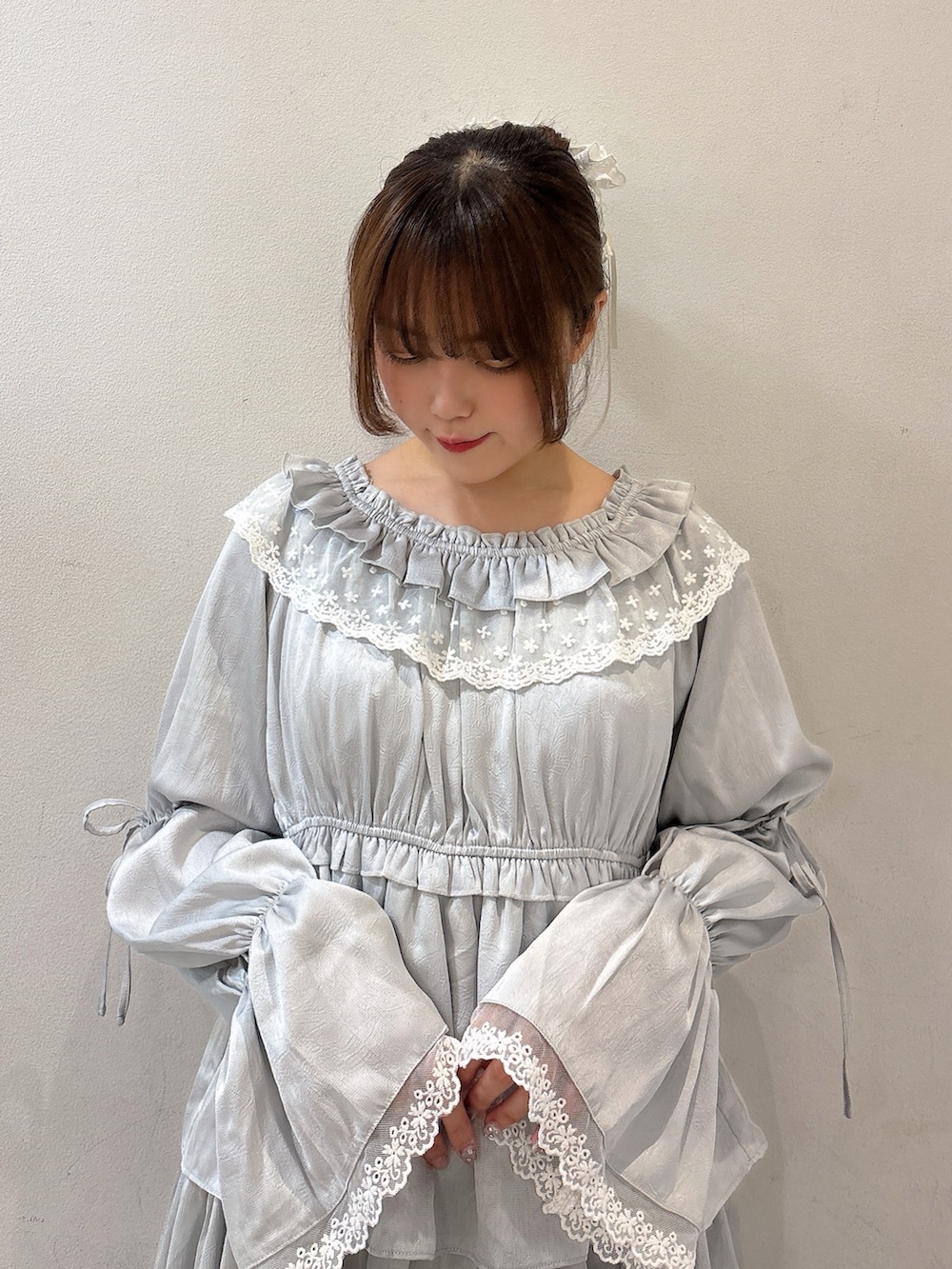 ブルー系のワンピース、ブルー系のハンドバッグ、ブルー系のデニムパンツを着用したレディースの夏コーディネートの5枚目の写真