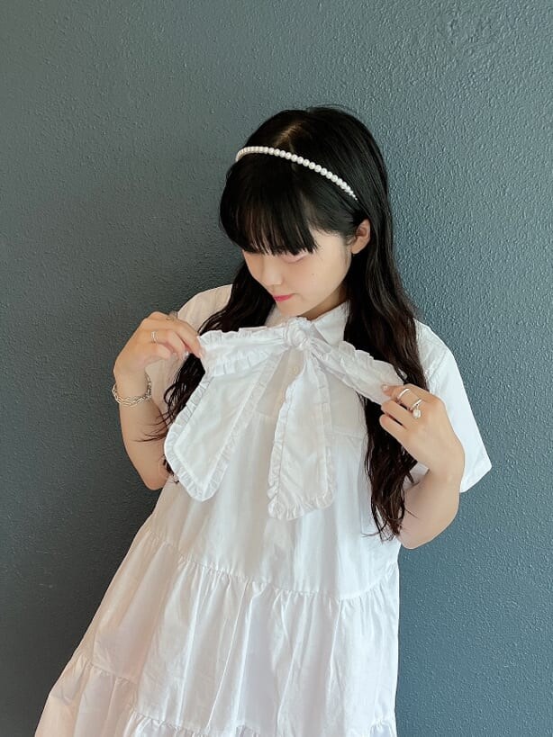 ベージュ系のサンダル、ピンク系のスラックス、ホワイト系のワンピースを着用したレディースの夏コーディネートの3枚目の写真