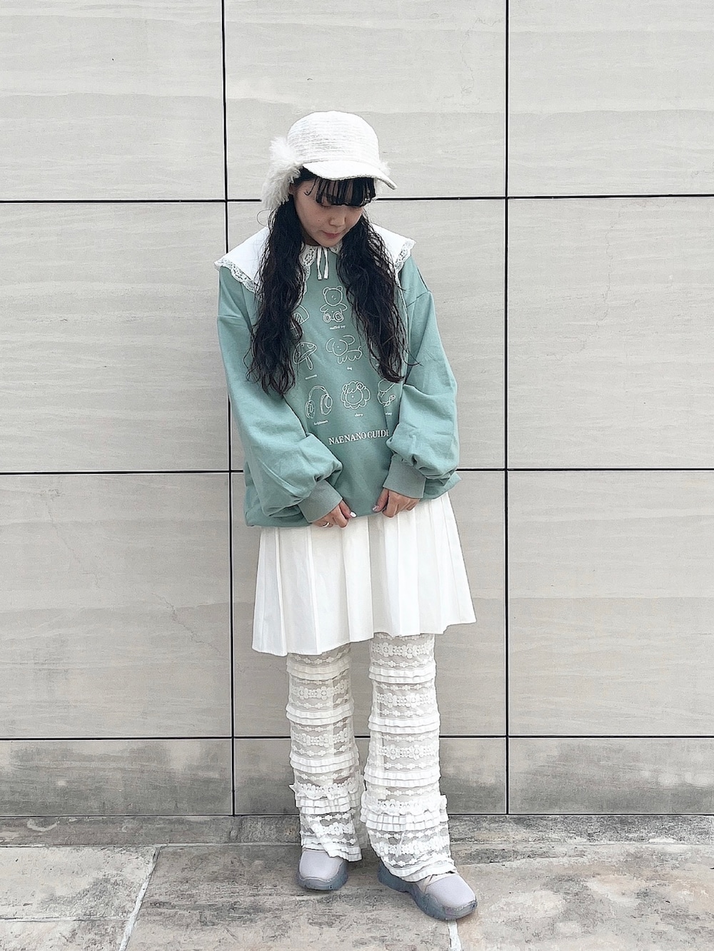 グリーン系のスウェット、ホワイト系のワンピース、ホワイト系のスウェットパンツを着用したレディースの秋コーディネートの2枚目の写真