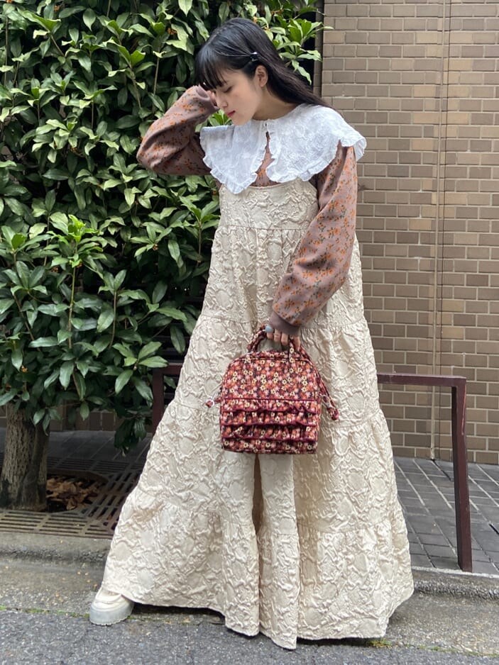 ベージュ系のワンピース、ホワイト系のシャツ/ブラウス、ホワイト系のローファーを着用したレディースの秋コーディネートの2枚目の写真