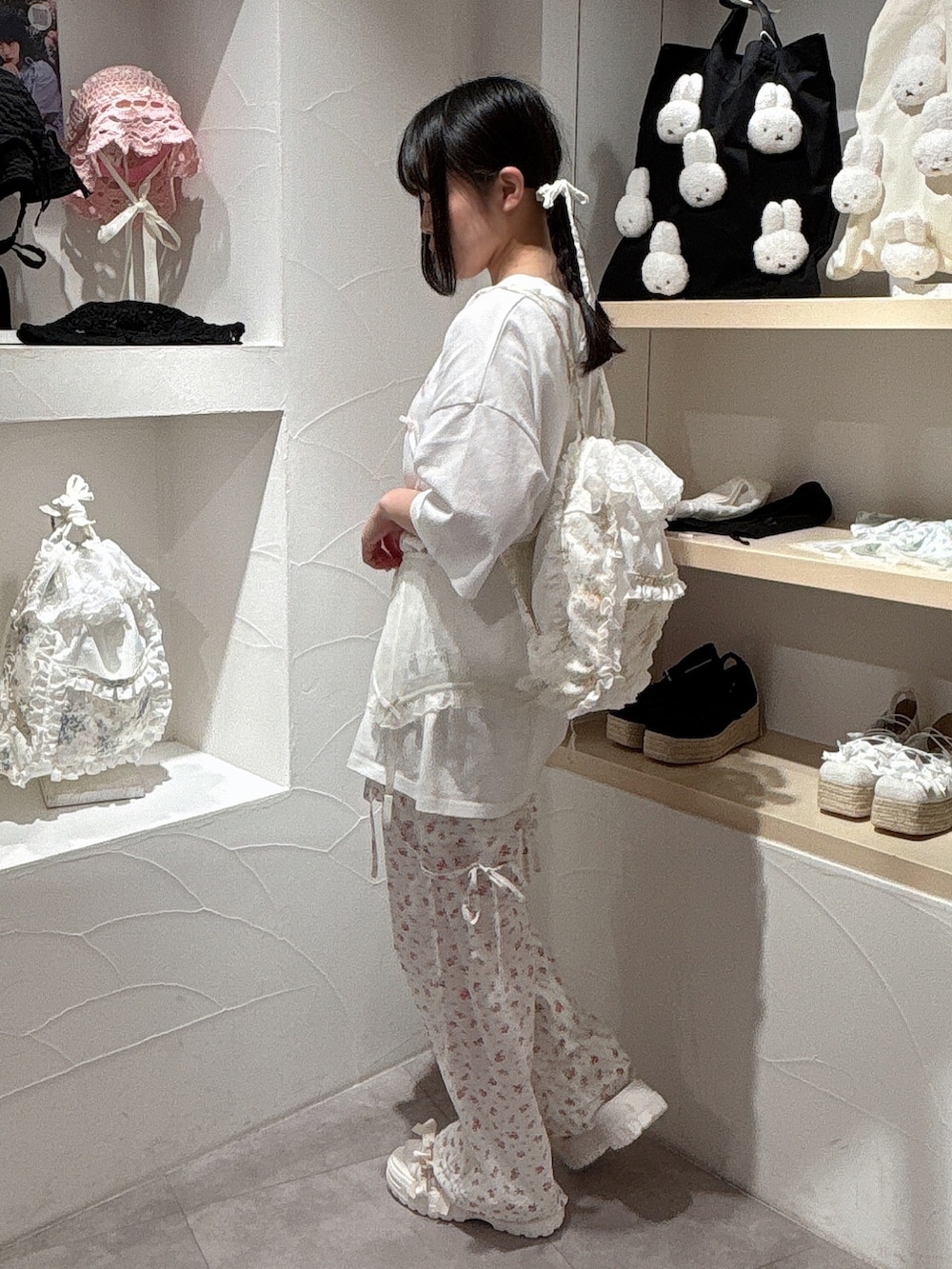 ホワイト系のTシャツ/カットソー、イエロー系のバックパック/リュック、ホワイト系のスラックスを着用したレディースの夏コーディネートの3枚目の写真