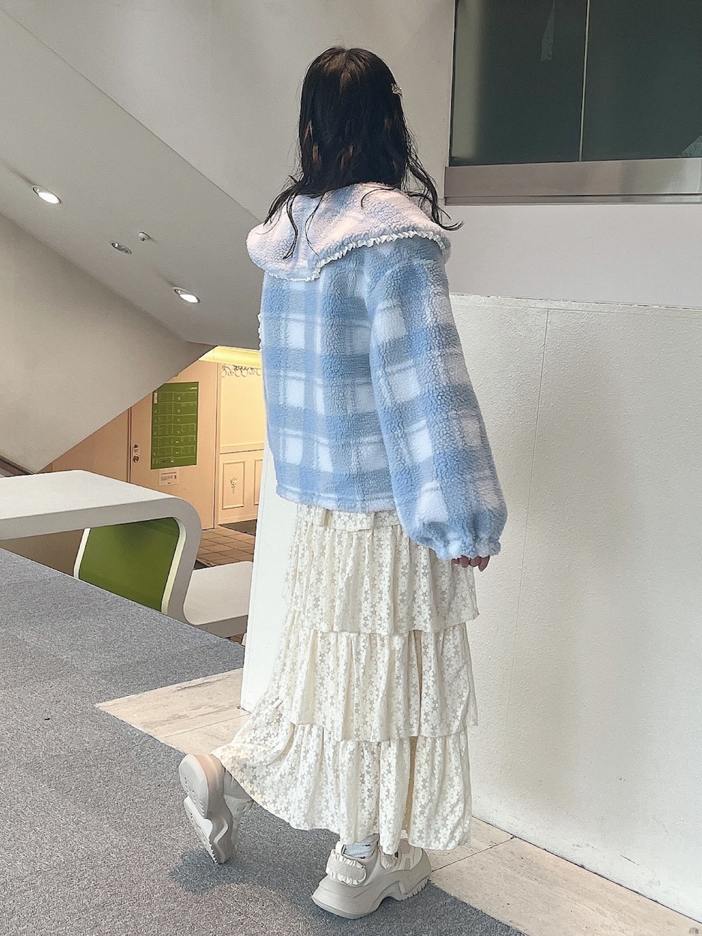 ホワイト系のスウェット、ブルー系のブルゾン、ホワイト系のスカートを着用したレディースの冬コーディネートの2枚目の写真