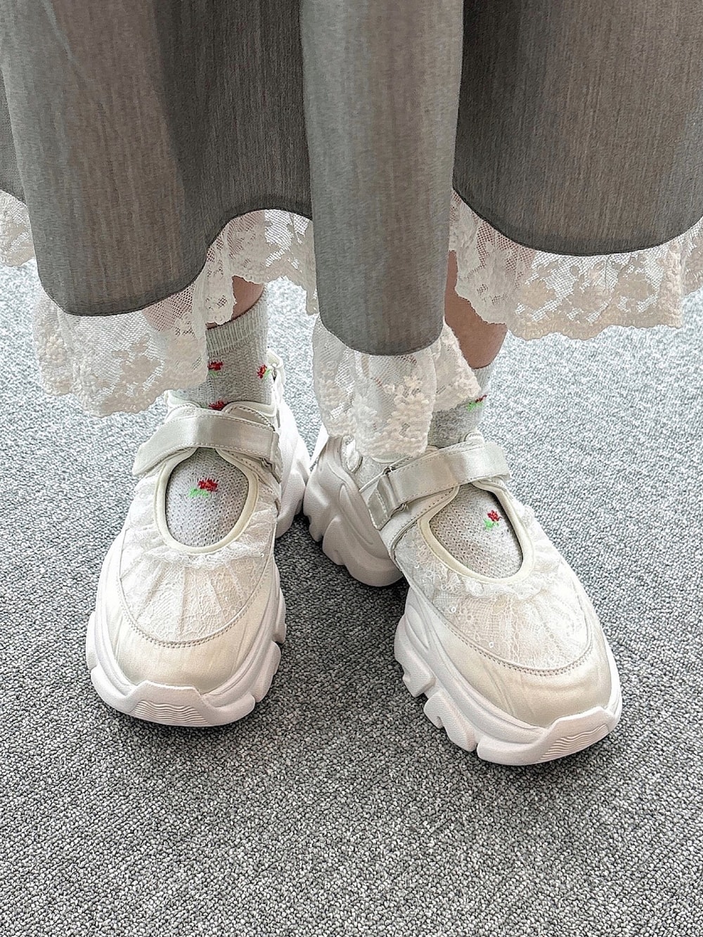 ブルー系のダウンジャケット/コート、ホワイト系のニット/セーター、グレー系のスカートを着用したレディースの秋コーディネートの9枚目の写真