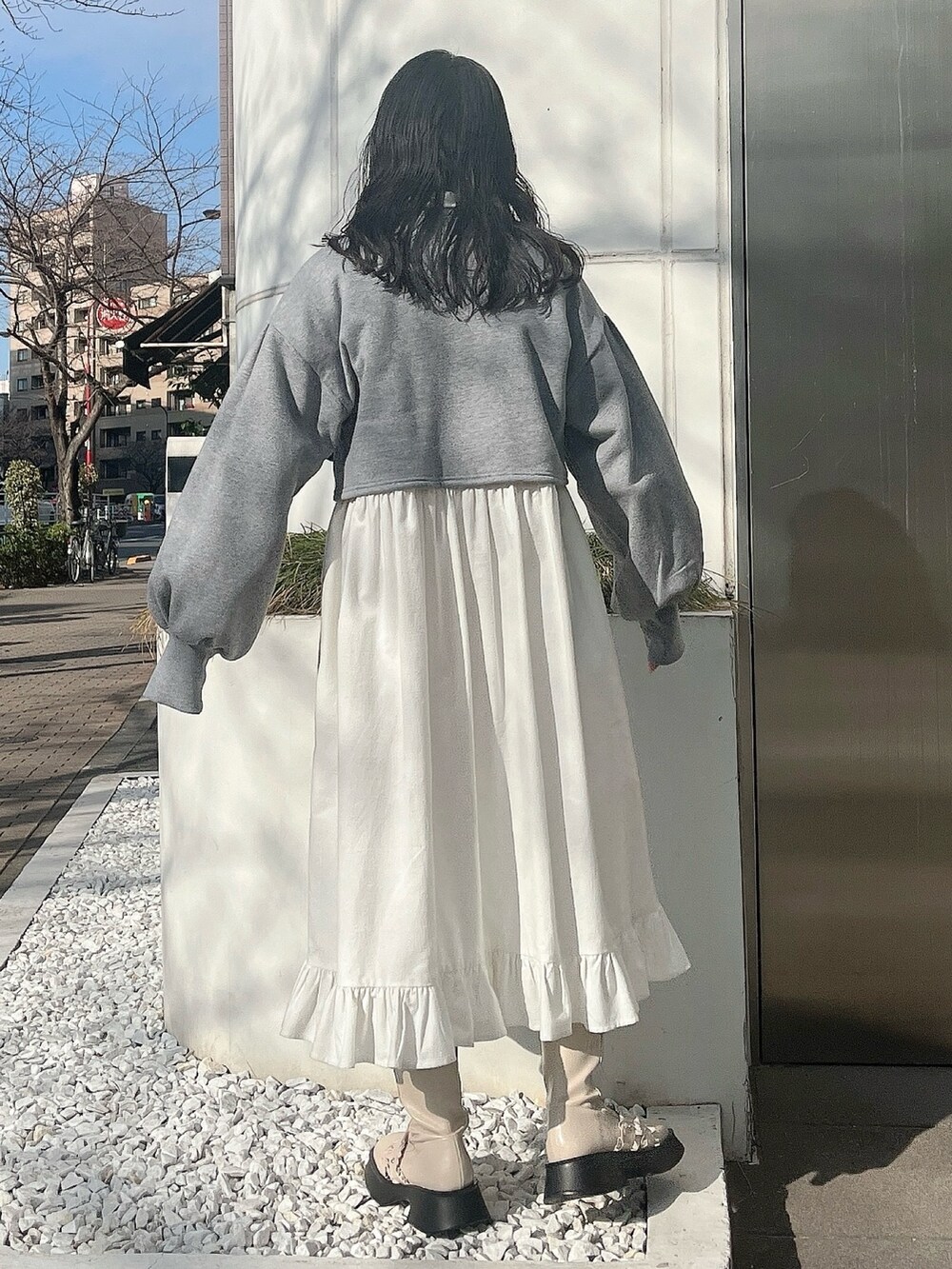 グレー系のカーディガン/ボレロ、ホワイト系のワンピース、ホワイト系のブーツを着用したレディースの冬コーディネートの4枚目の写真