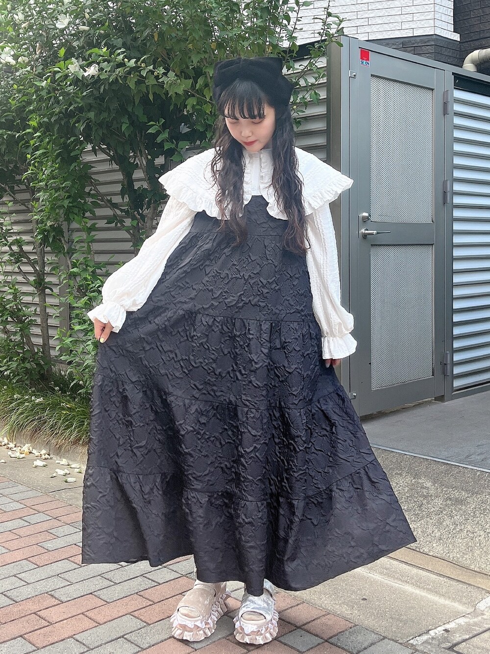 ホワイト系のシャツ/ブラウス、ブラック系のワンピース、ホワイト系のサンダルを着用したレディースの夏コーディネートの2枚目の写真