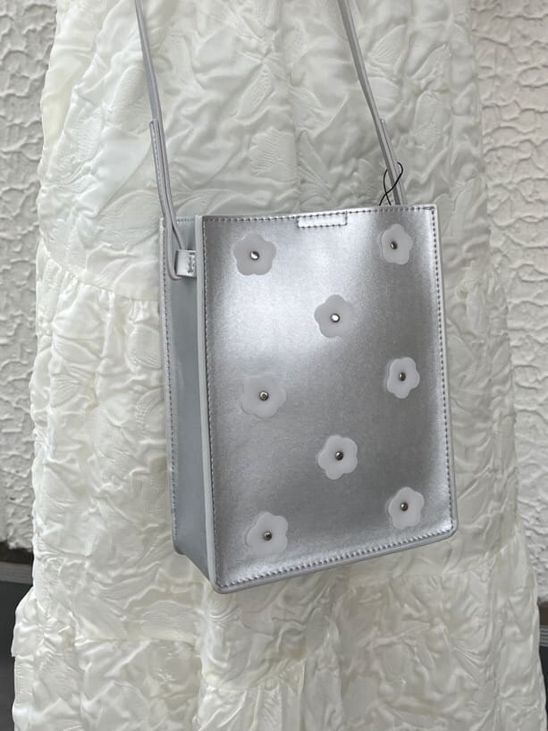 ホワイト系のパンプス、ホワイト系のワンピース、ブルー系のシャツ/ブラウスを着用したレディースの春コーディネートの3枚目の写真