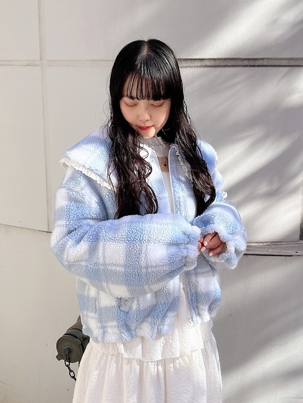 ホワイト系のスウェット、ブルー系のブルゾン、ホワイト系のスカートを着用したレディースの冬コーディネートの5枚目の写真