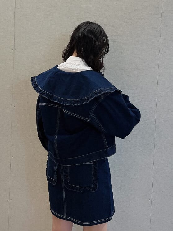 ブルー系のデニムジャケット、ホワイト系のブーツ、ホワイト系のボストンバッグを着用したレディースの夏コーディネートの5枚目の写真