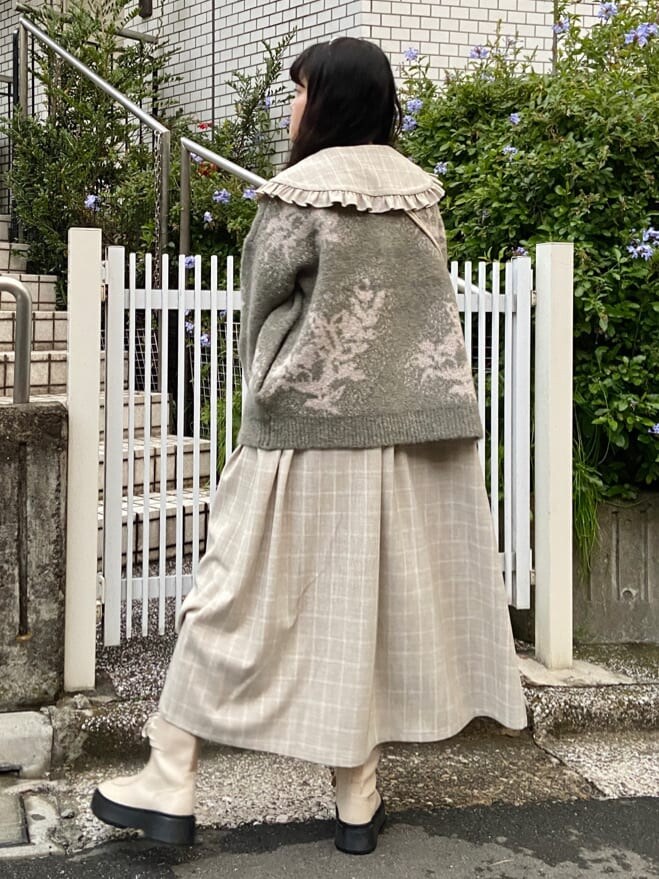 ホワイト系のブーツ、ホワイト系のハンドバッグ、ベージュ系のワンピースを着用したレディースの冬コーディネートの3枚目の写真