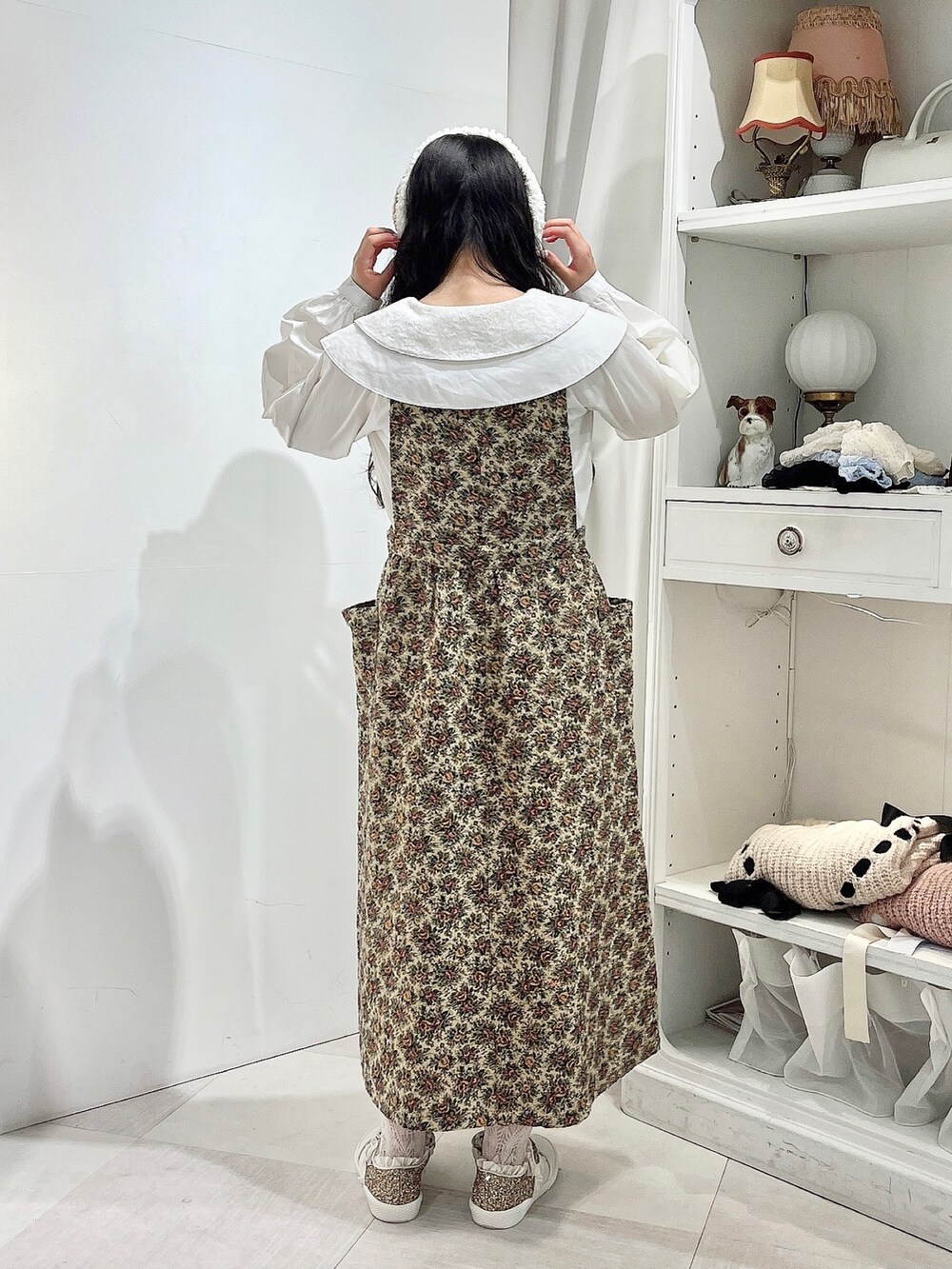 ホワイト系のシャツ/ブラウス、ベージュ系のジャンパースカート、ホワイト系のスニーカーを着用したレディースの秋コーディネートの5枚目の写真