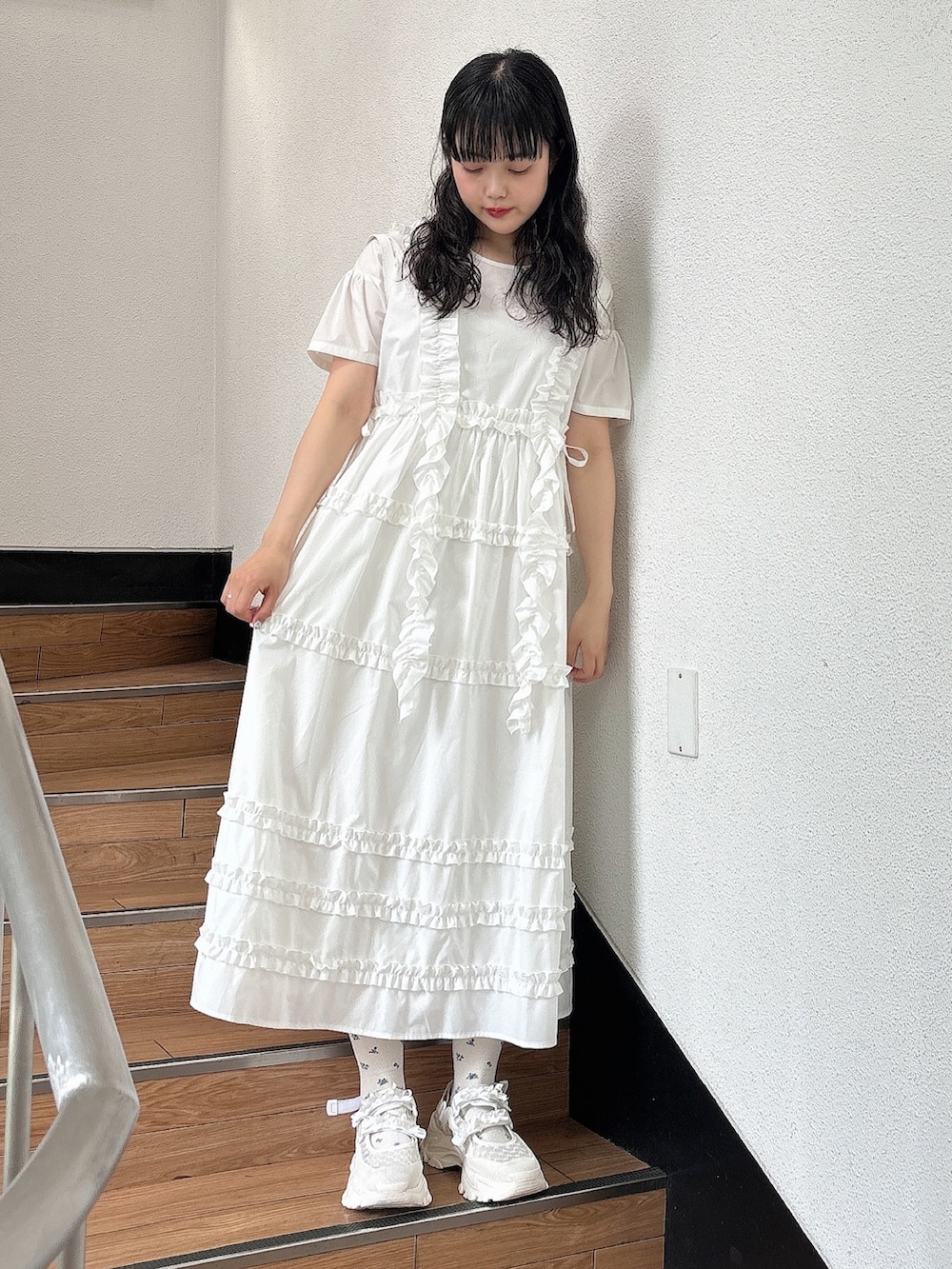 ホワイト系のスニーカー、ホワイト系のワンピース、ホワイト系のショルダーバッグを着用したレディースの夏コーディネートの2枚目の写真