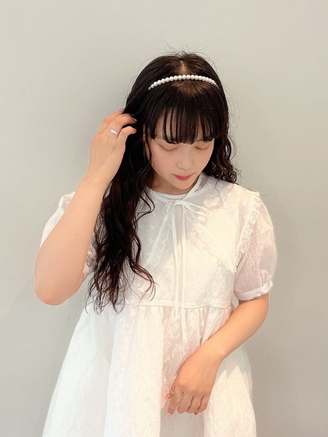 ホワイト系のスニーカー、ホワイト系のワンピース、ホワイト系のハンドバッグを着用したレディースの夏コーディネートの3枚目の写真