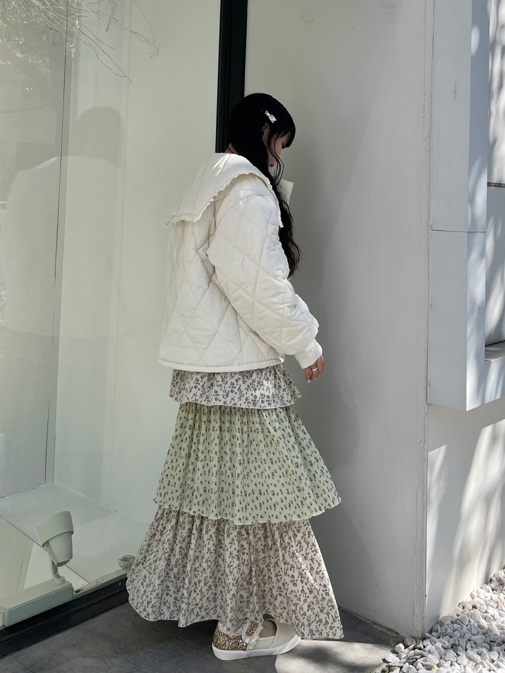 ホワイト系のダウンジャケット/コート、グリーン系のスカート、ホワイト系のスニーカーを着用したレディースの冬コーディネートの3枚目の写真