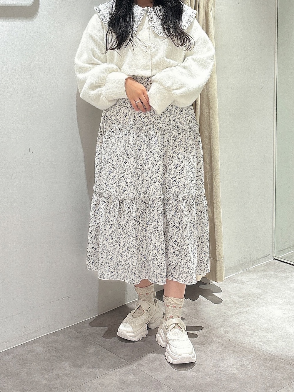 ホワイト系のカーディガン/ボレロ、ホワイト系のワンピース、ホワイト系のスニーカーを着用したレディースの秋コーディネートの3枚目の写真