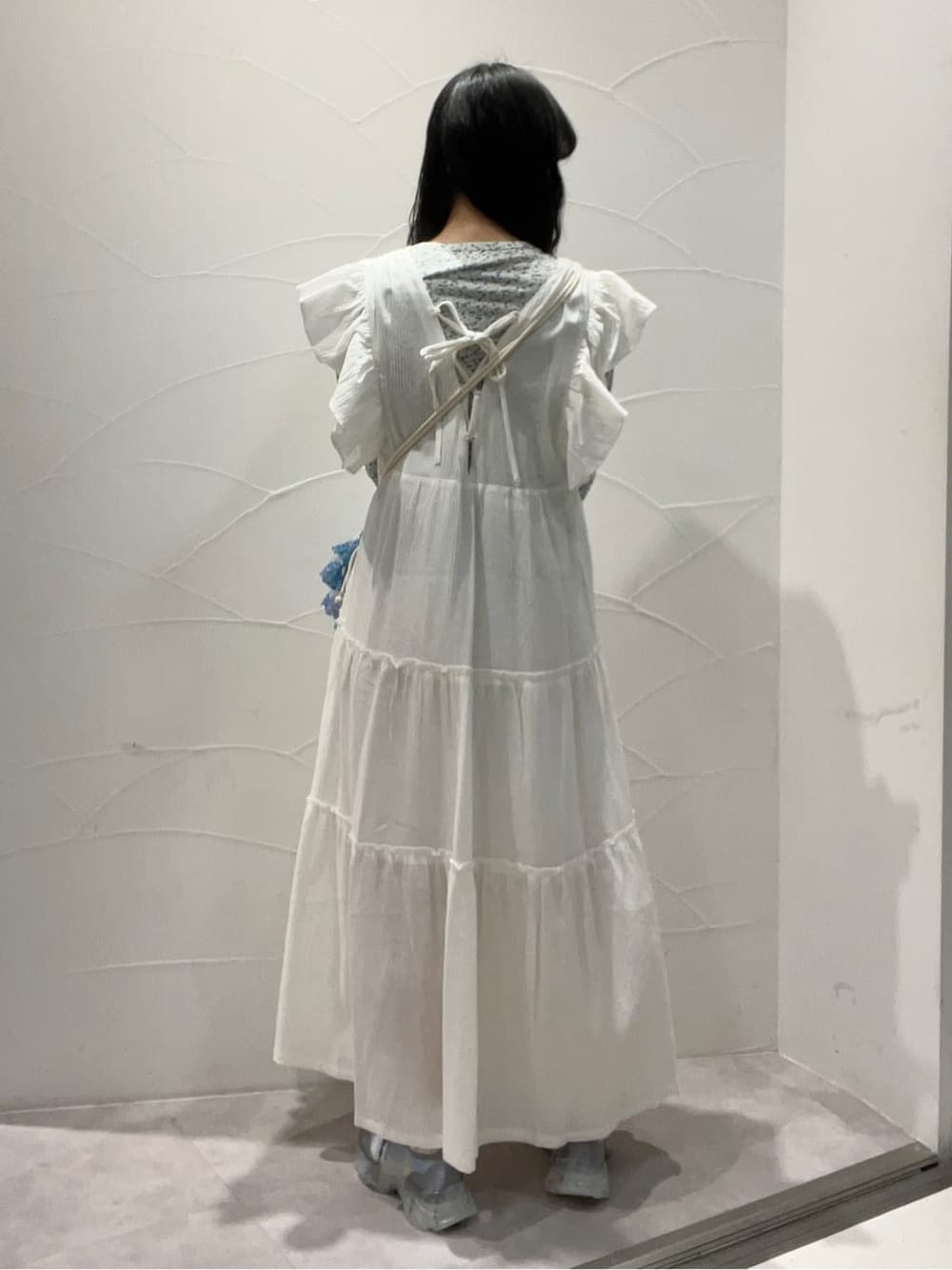 ホワイト系のワンピース、ブルー系のスニーカー、ブルー系のハンドバッグを着用したレディースの冬コーディネートの3枚目の写真