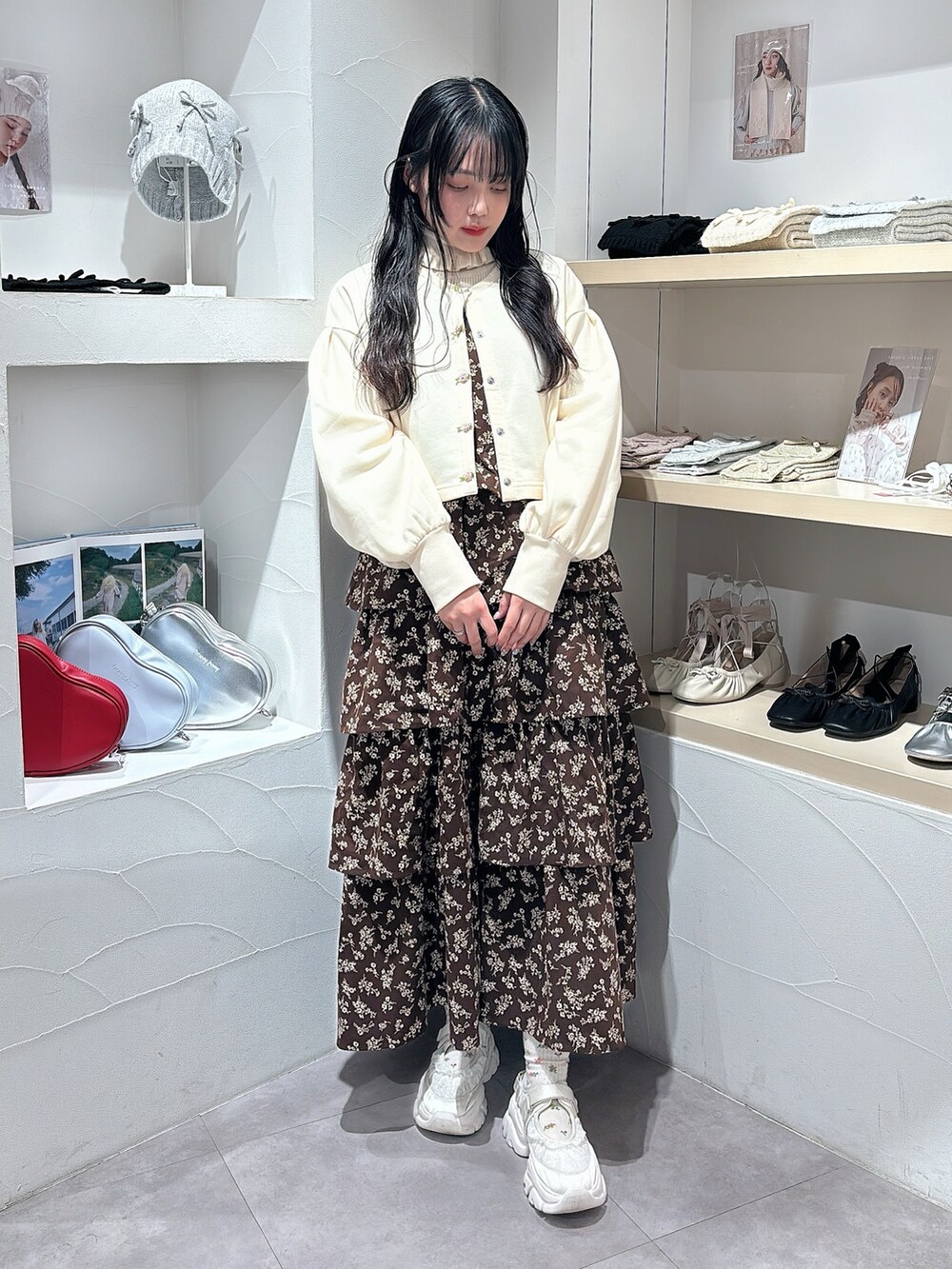 ホワイト系のニット/セーター、ホワイト系のカーディガン/ボレロ、ブラウン系のワンピースを着用したレディースの秋コーディネートの2枚目の写真