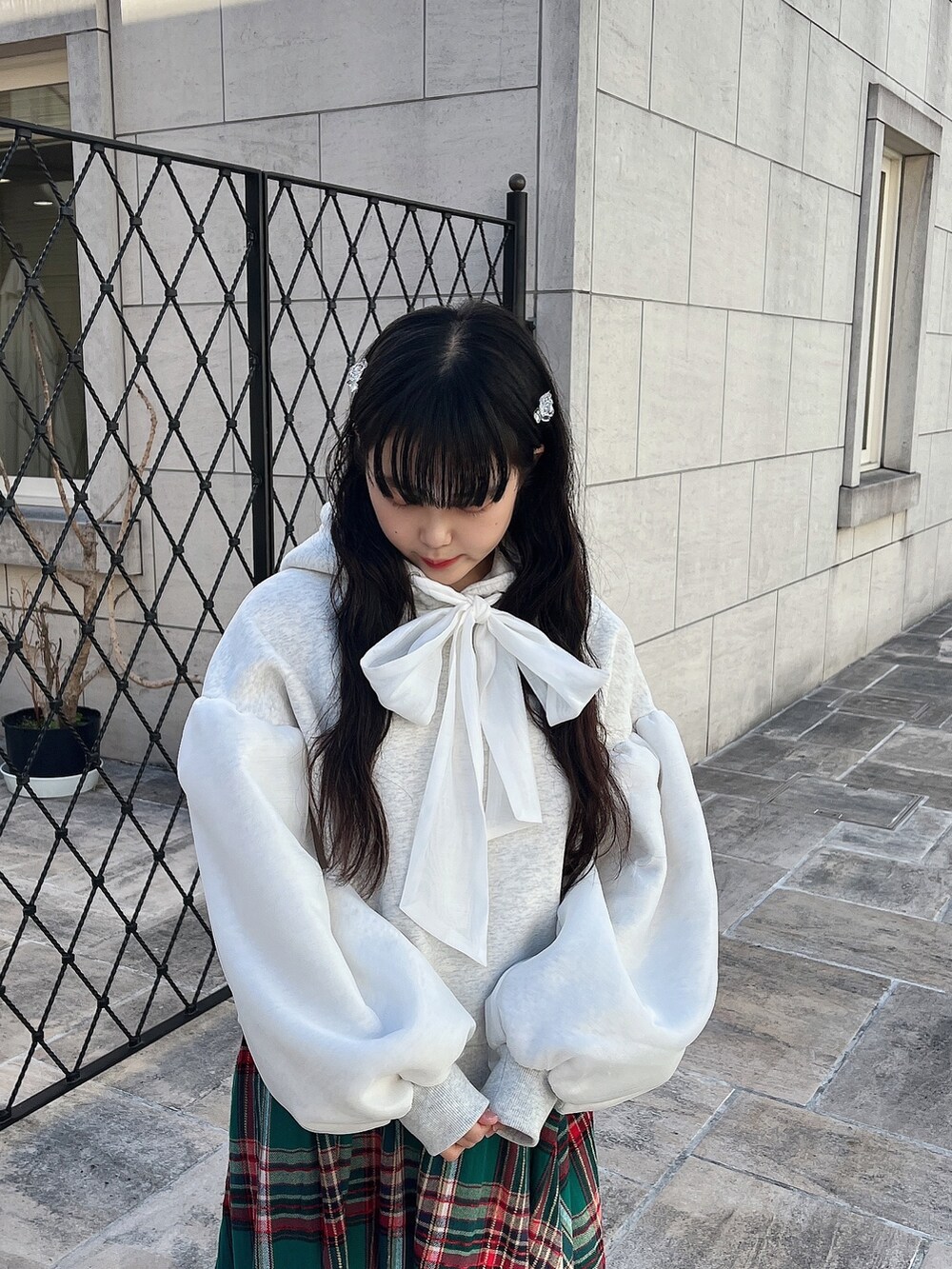 ホワイト系のパーカー、ホワイト系のその他アウター、グリーン系のスカートを着用したレディースの冬コーディネートの7枚目の写真