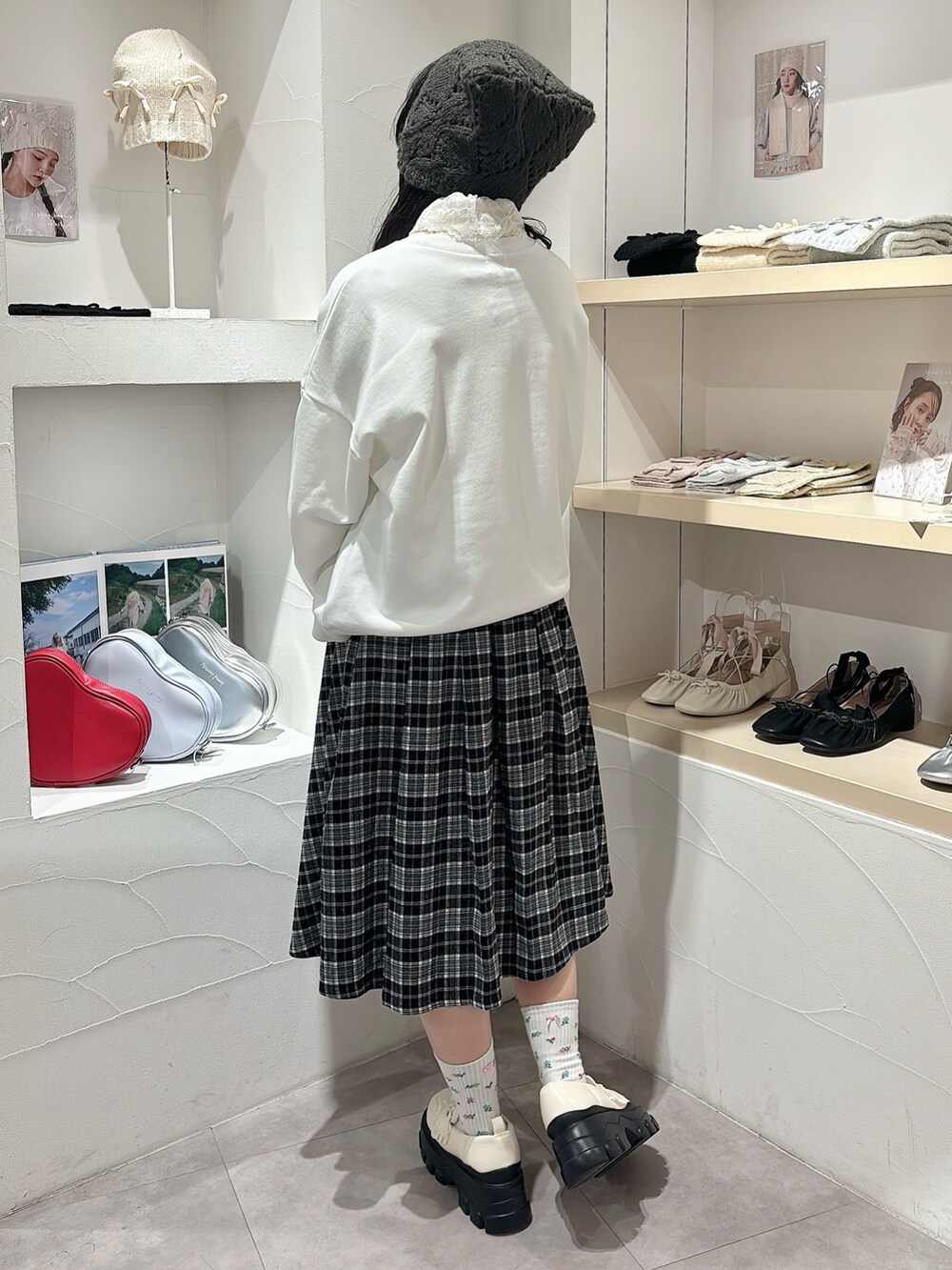 ホワイト系のニット/セーター、ホワイト系のスウェット、ブラック系のスカートを着用したレディースの秋コーディネートの4枚目の写真