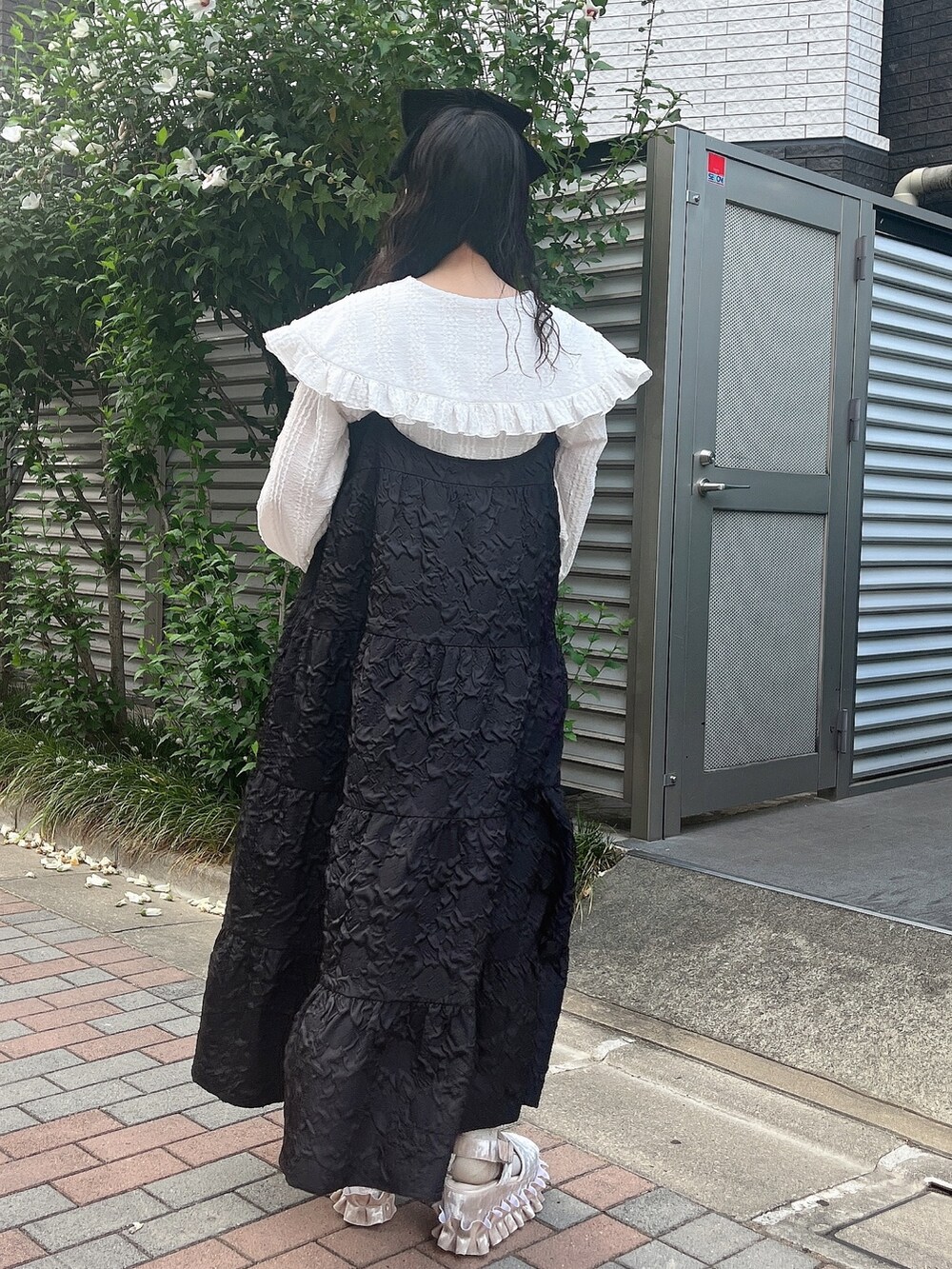 ホワイト系のシャツ/ブラウス、ブラック系のワンピース、ホワイト系のサンダルを着用したレディースの夏コーディネートの3枚目の写真