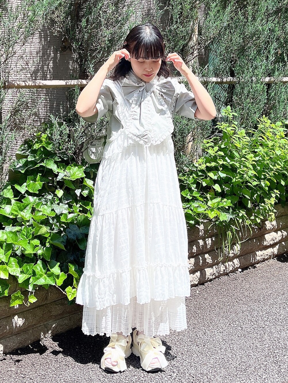 グリーン系のシャツ/ブラウス、ホワイト系のワンピース、ホワイト系のスカートを着用したレディースの夏コーディネートの2枚目の写真