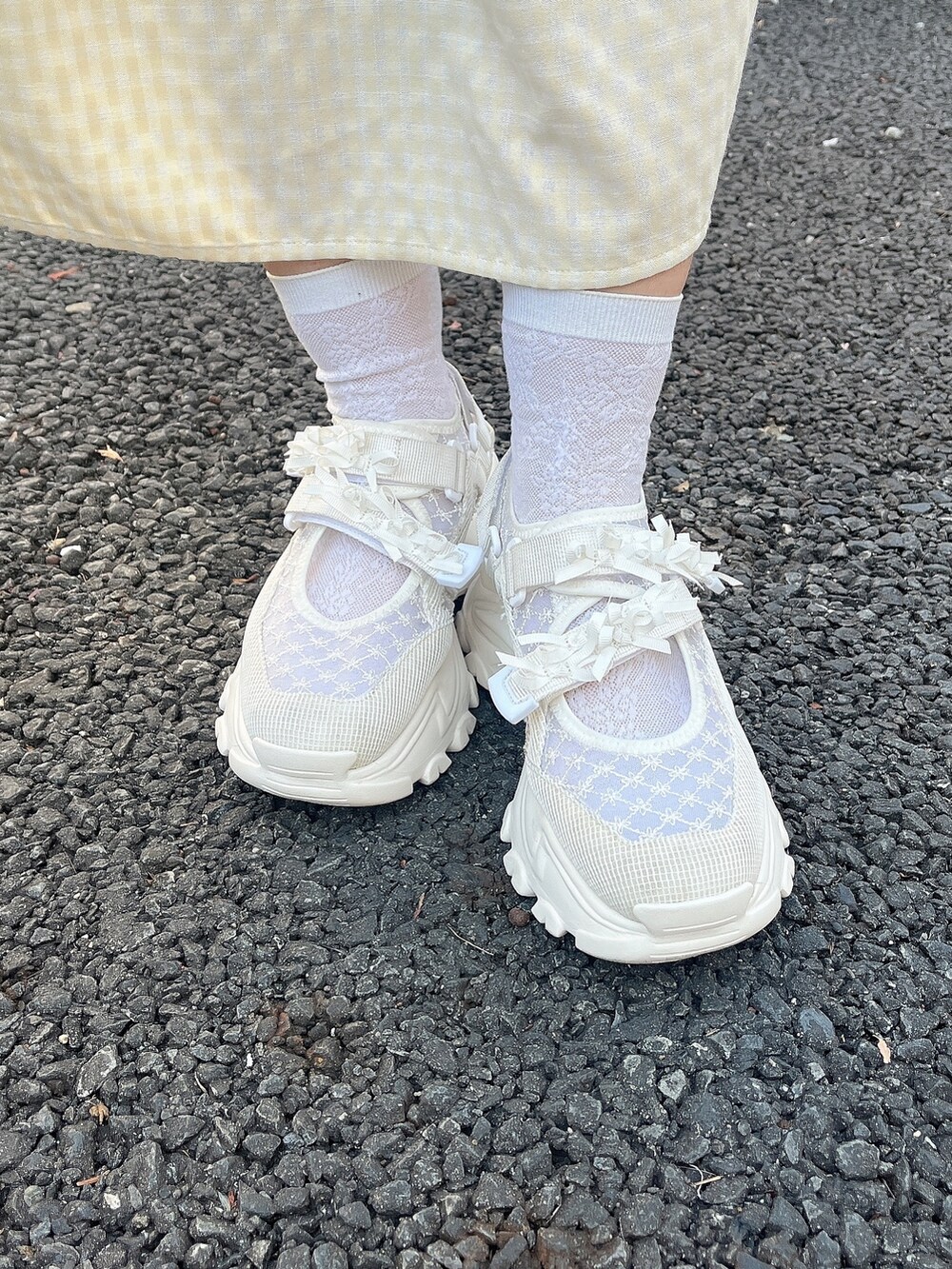 イエロー系のワンピース、ブルー系のカーディガン/ボレロ、ホワイト系のスニーカーを着用したレディースの冬コーディネートの8枚目の写真