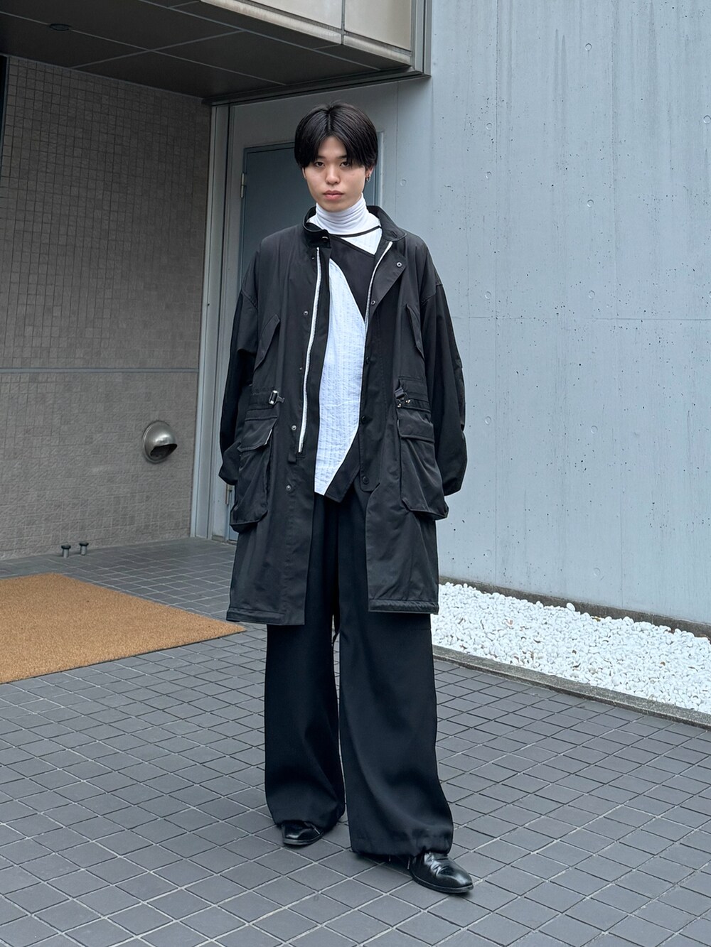 ホワイト系のベスト、ホワイト系のその他トップス、ブラック系のカーゴパンツを着用したメンズの春コーディネートの5枚目の写真