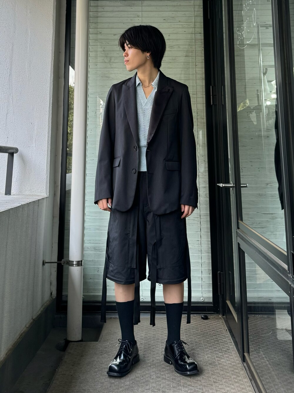 ブラック系のテーラードジャケット、ブラック系のカーゴパンツ、ブラック系のブーツを着用したメンズの秋コーディネートの2枚目の写真