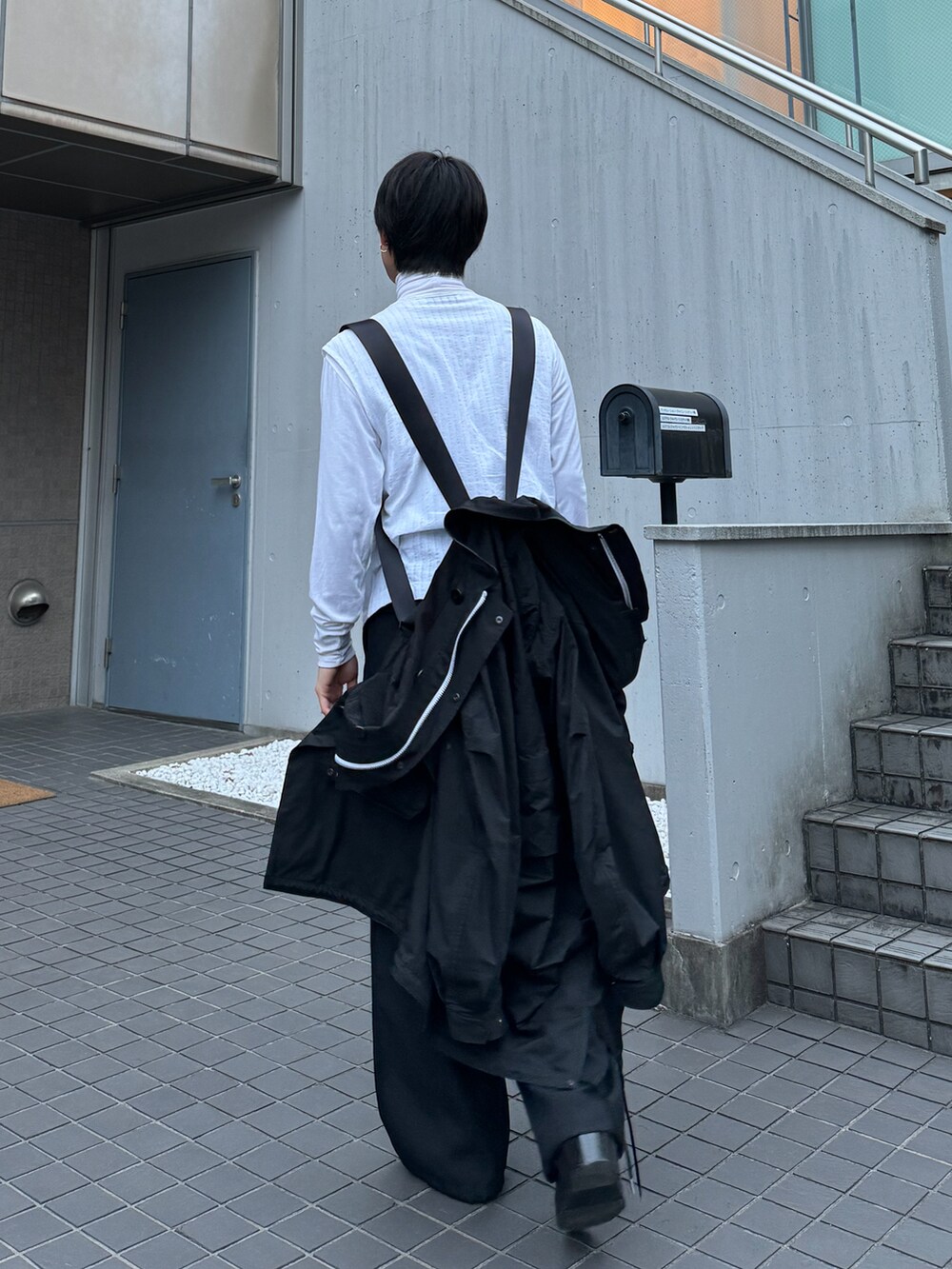 ホワイト系のベスト、ホワイト系のその他トップス、ブラック系のカーゴパンツを着用したメンズの春コーディネートの3枚目の写真