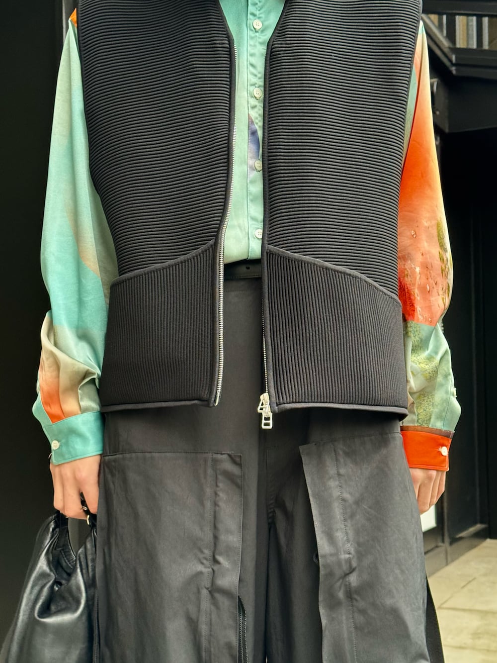 オレンジ系のシャツ/ブラウス、ブラック系のカーゴパンツ、ホワイト系のスニーカーを着用したメンズの春コーディネートの4枚目の写真