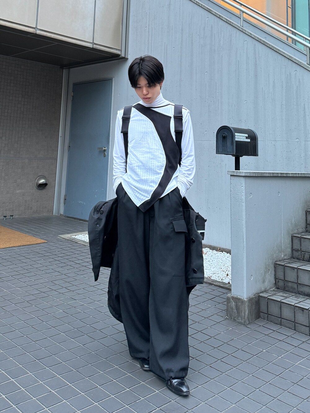 ホワイト系のベスト、ホワイト系のその他トップス、ブラック系のカーゴパンツを着用したメンズの春コーディネートの2枚目の写真