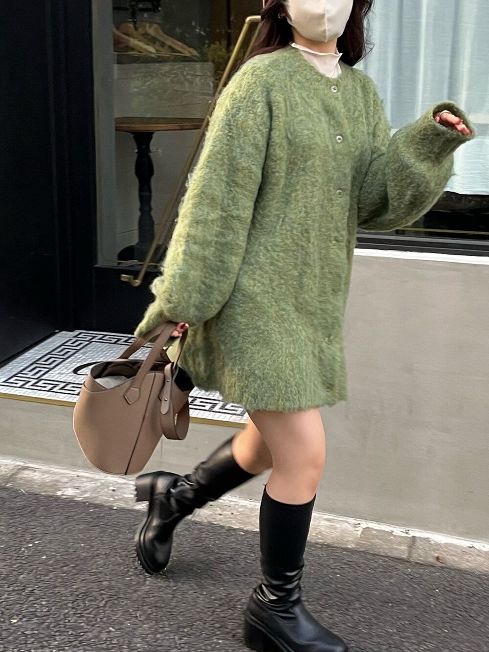 ブラック系のブーツ、グリーン系のカーディガン/ボレロ、ベージュ系のハットを着用したレディースの秋コーディネートの2枚目の写真