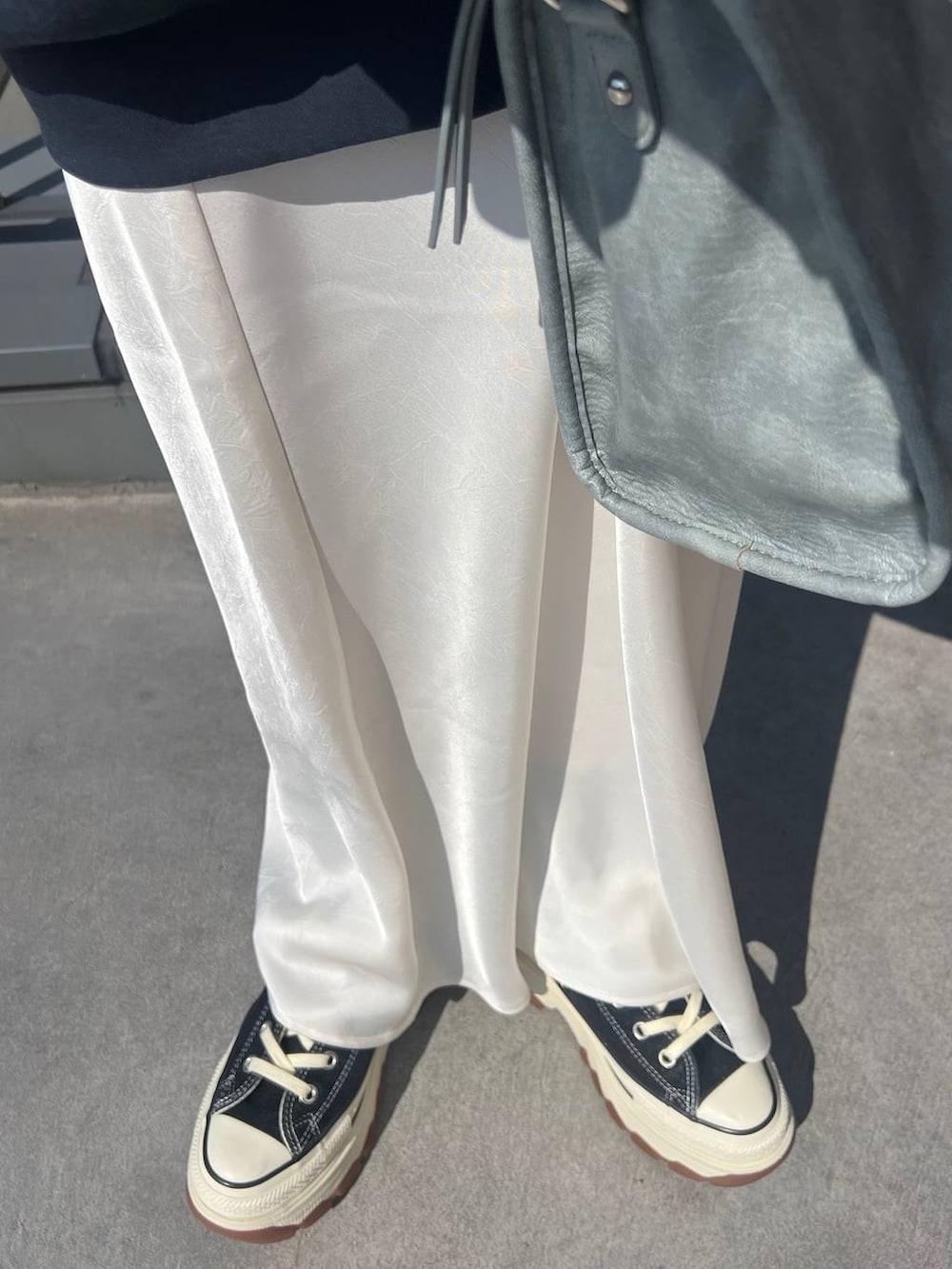 ホワイト系のTシャツ/カットソー、ブラック系のスニーカー、ホワイト系のスカートを着用したレディースの春コーディネートの6枚目の写真