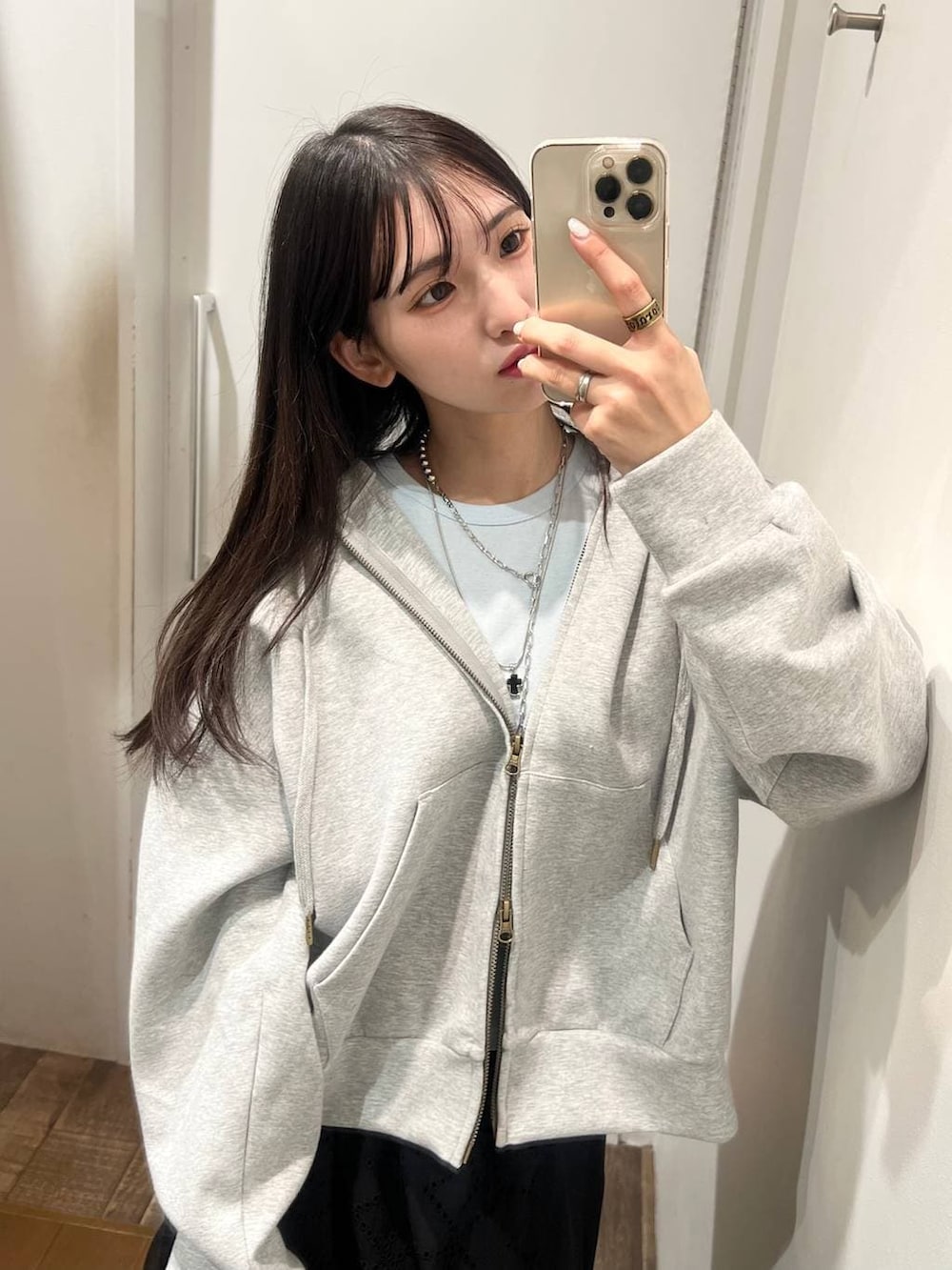 ブルー系のスニーカー、グレー系のパーカー、ブラック系のスカートを着用したレディースの春コーディネートの5枚目の写真