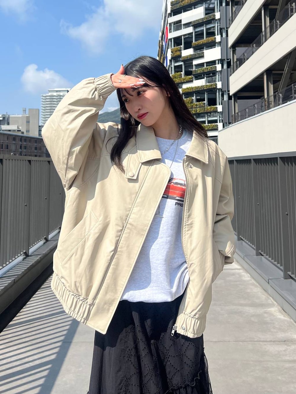 ブルー系のスニーカー、グレー系のスウェット、ベージュ系のブルゾンを着用したレディースの春コーディネートの2枚目の写真