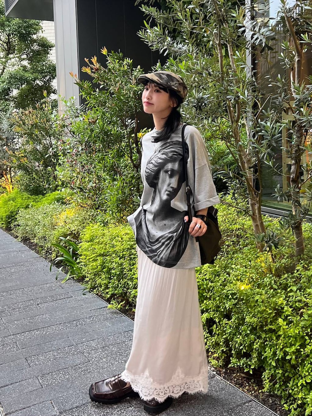 ブラウン系のローファー、グレー系のTシャツ/カットソー、ホワイト系のスカートを着用したレディースの夏コーディネートの2枚目の写真