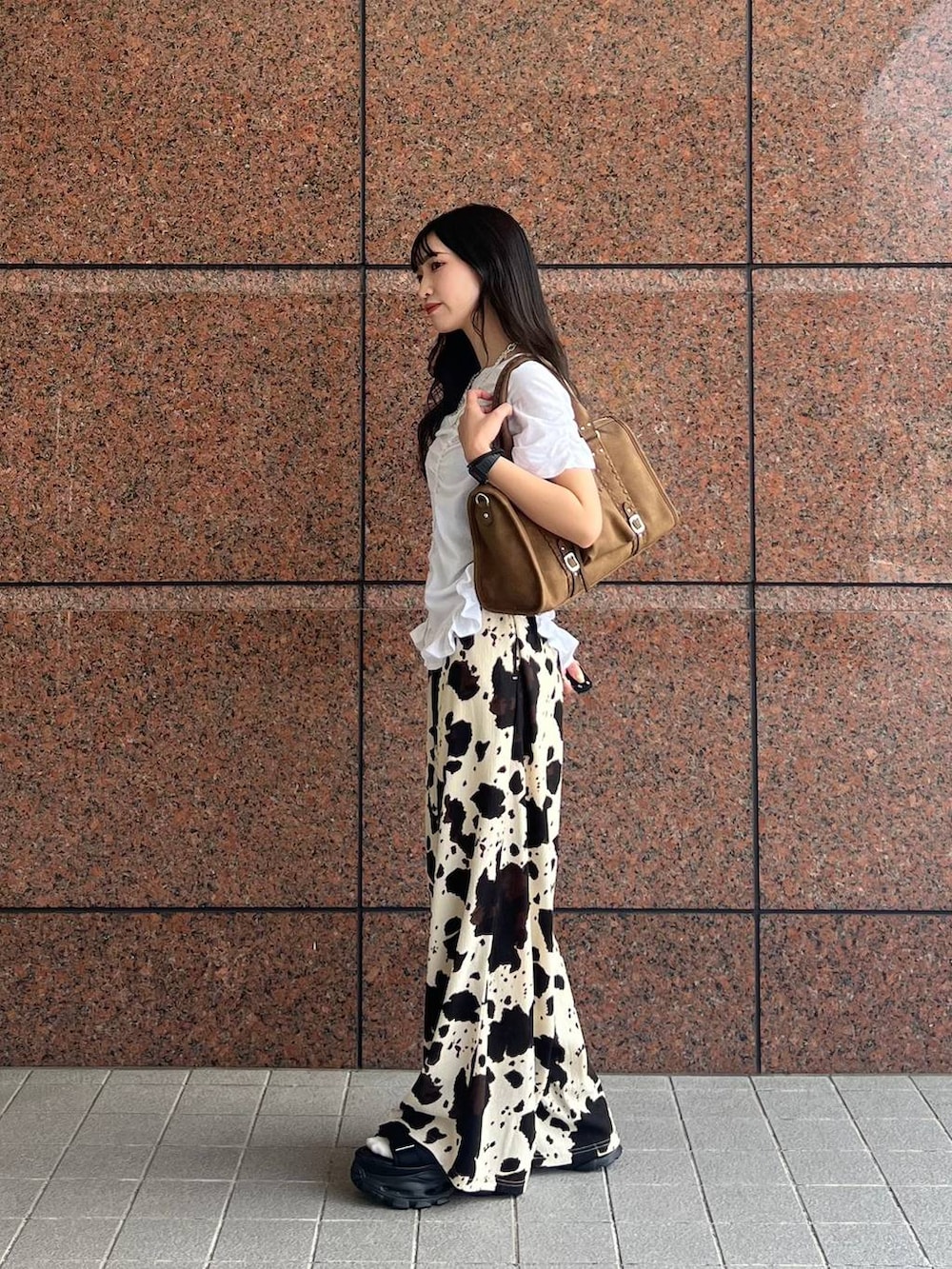 ベージュ系のその他パンツ、ブラウン系のボストンバッグ、ブラック系のサンダルを着用したレディースの夏コーディネートの2枚目の写真