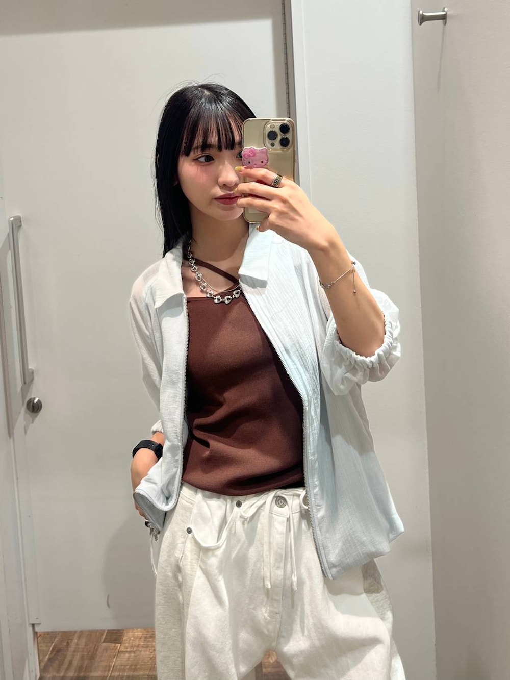 ホワイト系のデニムパンツ、ブラウン系のタンクトップ、ブラック系のパンプスを着用したレディースの夏コーディネートの2枚目の写真