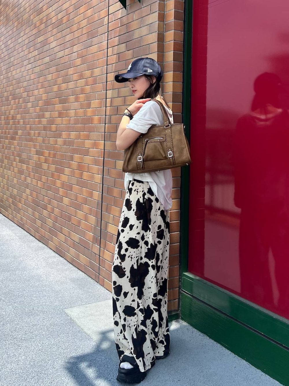 ブラック系のその他パンツ、ブラウン系のボストンバッグ、ブラック系のサンダルを着用したレディースの夏コーディネートの6枚目の写真