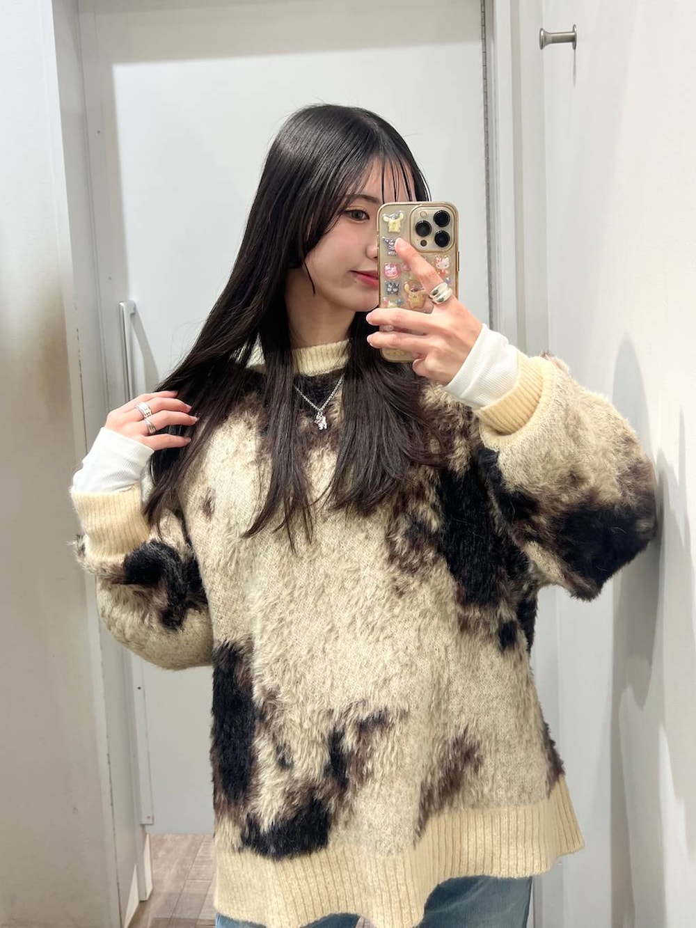 ホワイト系のTシャツ/カットソー、ブラウン系のニット/セーター、ブラック系のスニーカーを着用したレディースの冬コーディネートの2枚目の写真