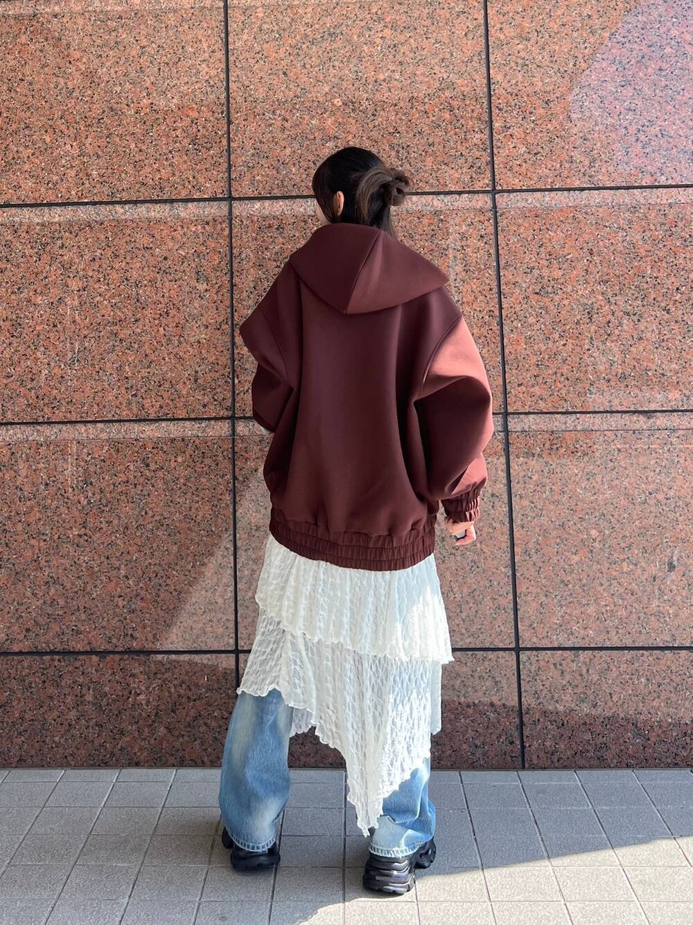 ブラウン系のパーカー、ブラウン系のローファー、ブルー系のデニムパンツを着用したレディースの秋コーディネートの4枚目の写真