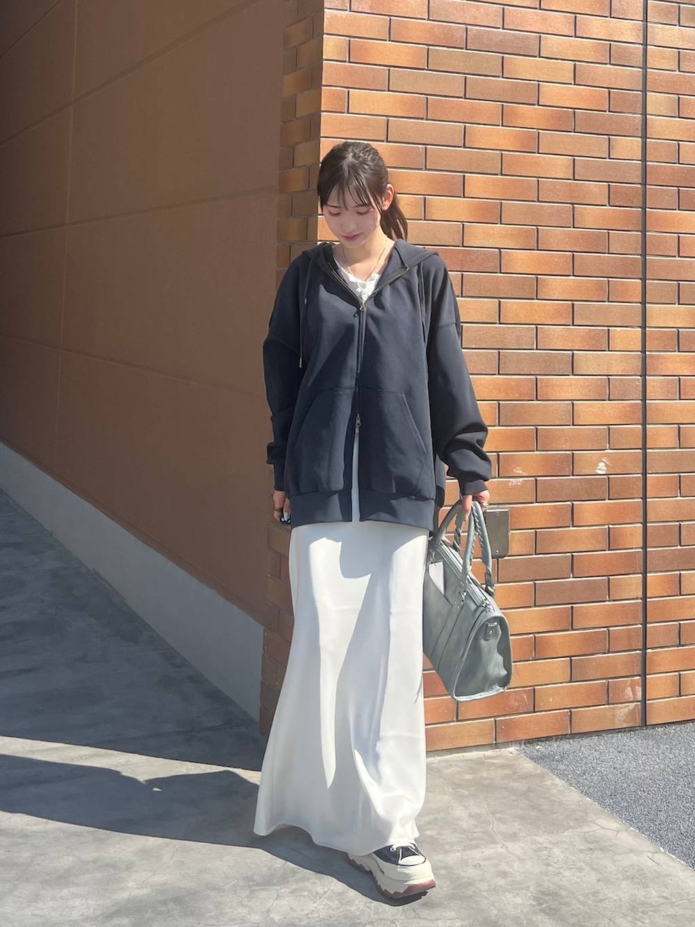 ホワイト系のTシャツ/カットソー、ブラック系のスニーカー、ホワイト系のスカートを着用したレディースの春コーディネートの9枚目の写真