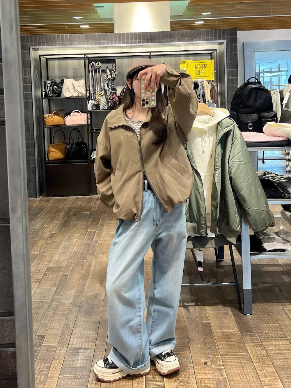 ホワイト系のTシャツ/カットソー、ブラック系のスニーカー、ブルー系のデニムパンツを着用したレディースの冬コーディネートの4枚目の写真